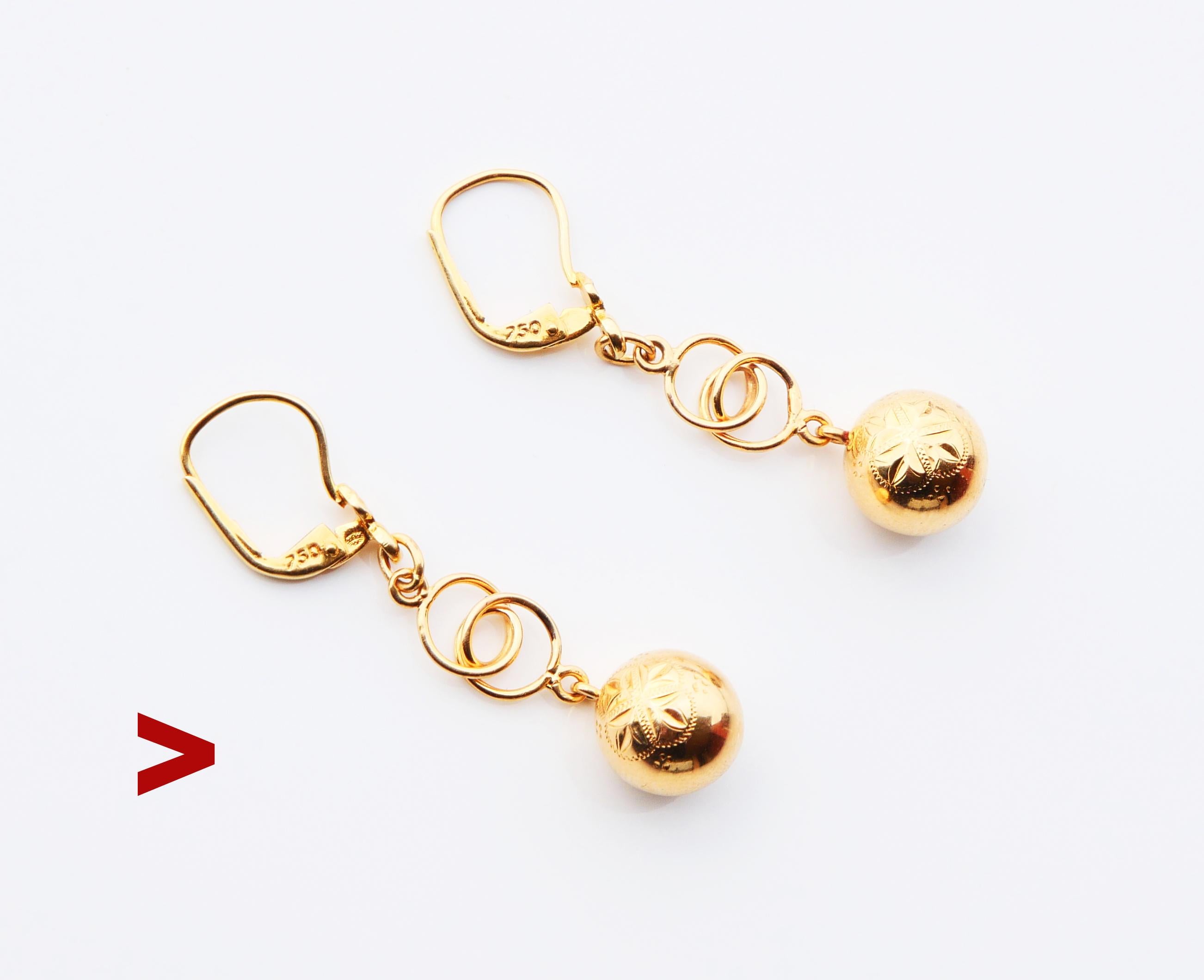 A pair of Earrings with chained shiny balls made ca. 1920s -1930s. Delicately engraved ornaments of Octagonal eight-angled stars on the front sides.

750 hallmarks on hooks, metal was tested solid 18K Yellow Gold.

Each earring is 40 mm long and