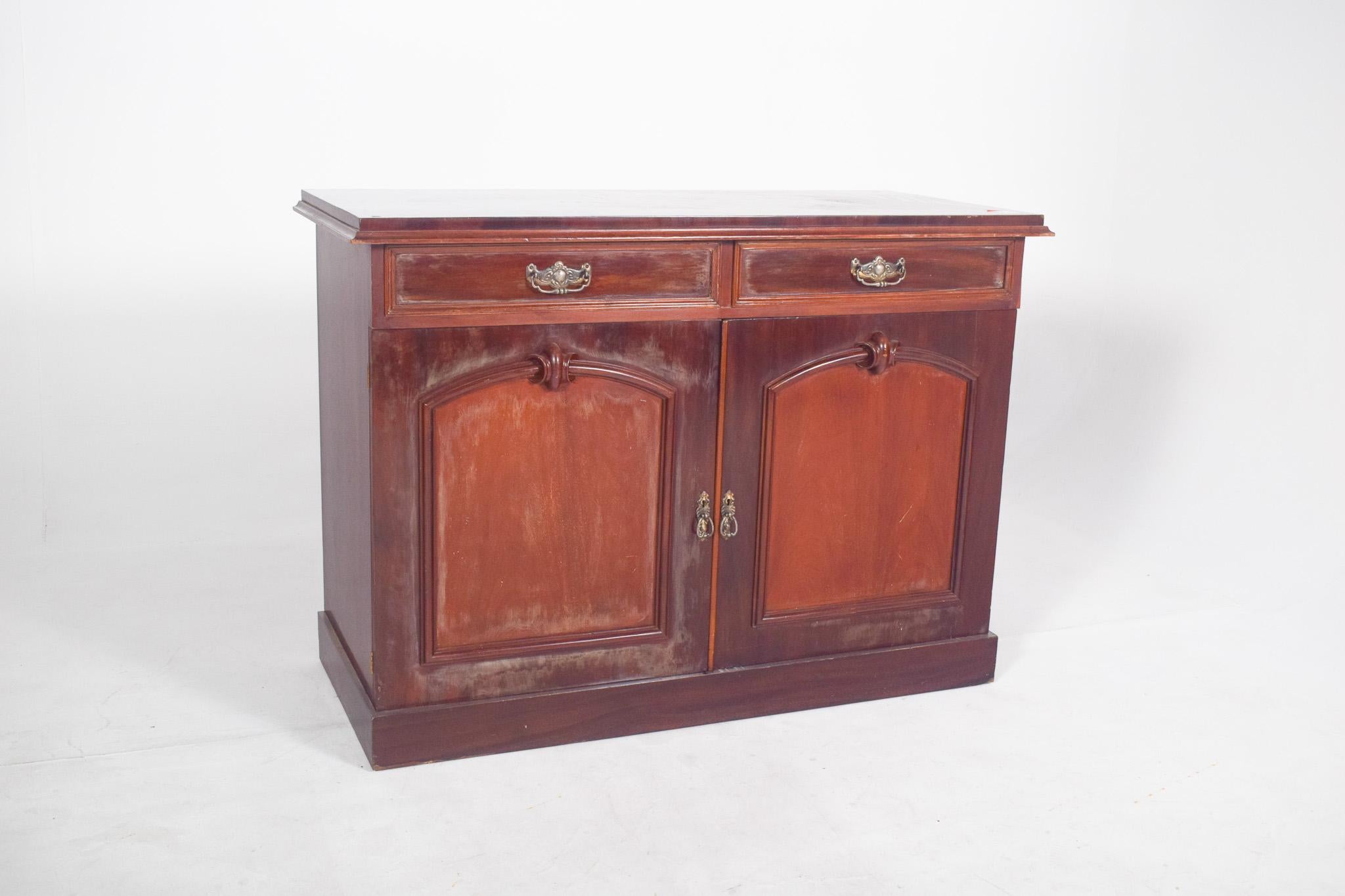 English-style tall sideboard. With two top drawers, each with a yellow metal handle. Below, two doors with recessed ogival arch panels and embossed centre decoration, also with decorated yellow metal handles. The two doors open onto a single