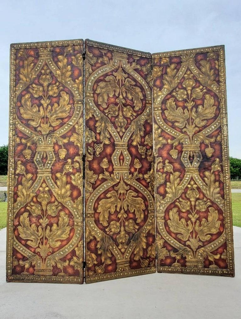 A spectacular antique European (likely Spanish or French) fine quality and elaborately decorated three panel folding screen room divider. 

Born in the late 19th / early 20th century, richly detailed applique embossed leather on a hardwood frame,