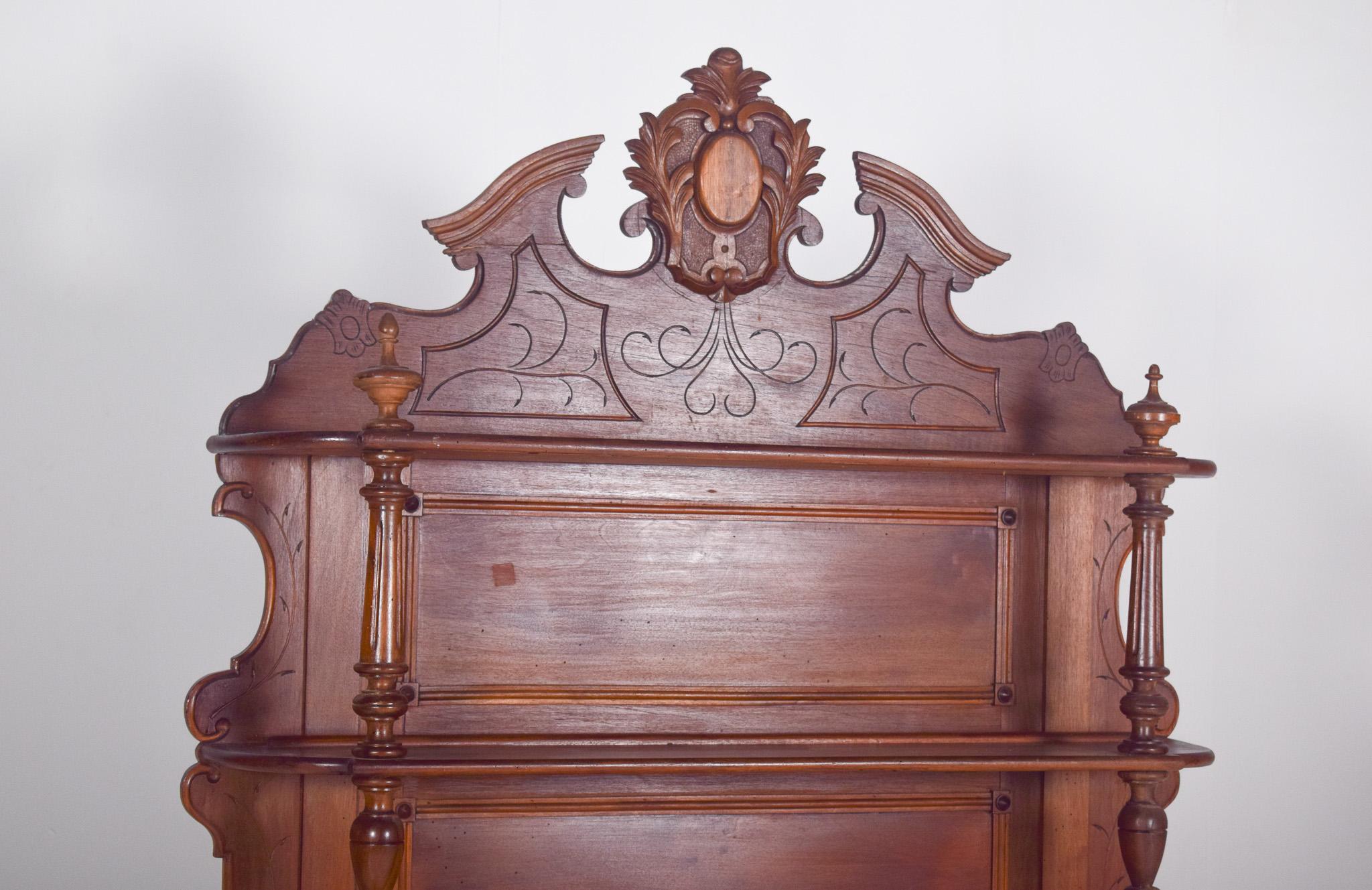 Henry II-style sideboard.  The lower part has a pink marble top, two upper drawers with carved metal handles and two lower doors with visible hinges and central metal locks. The front columns are turned, with a square base and top.
The top of the