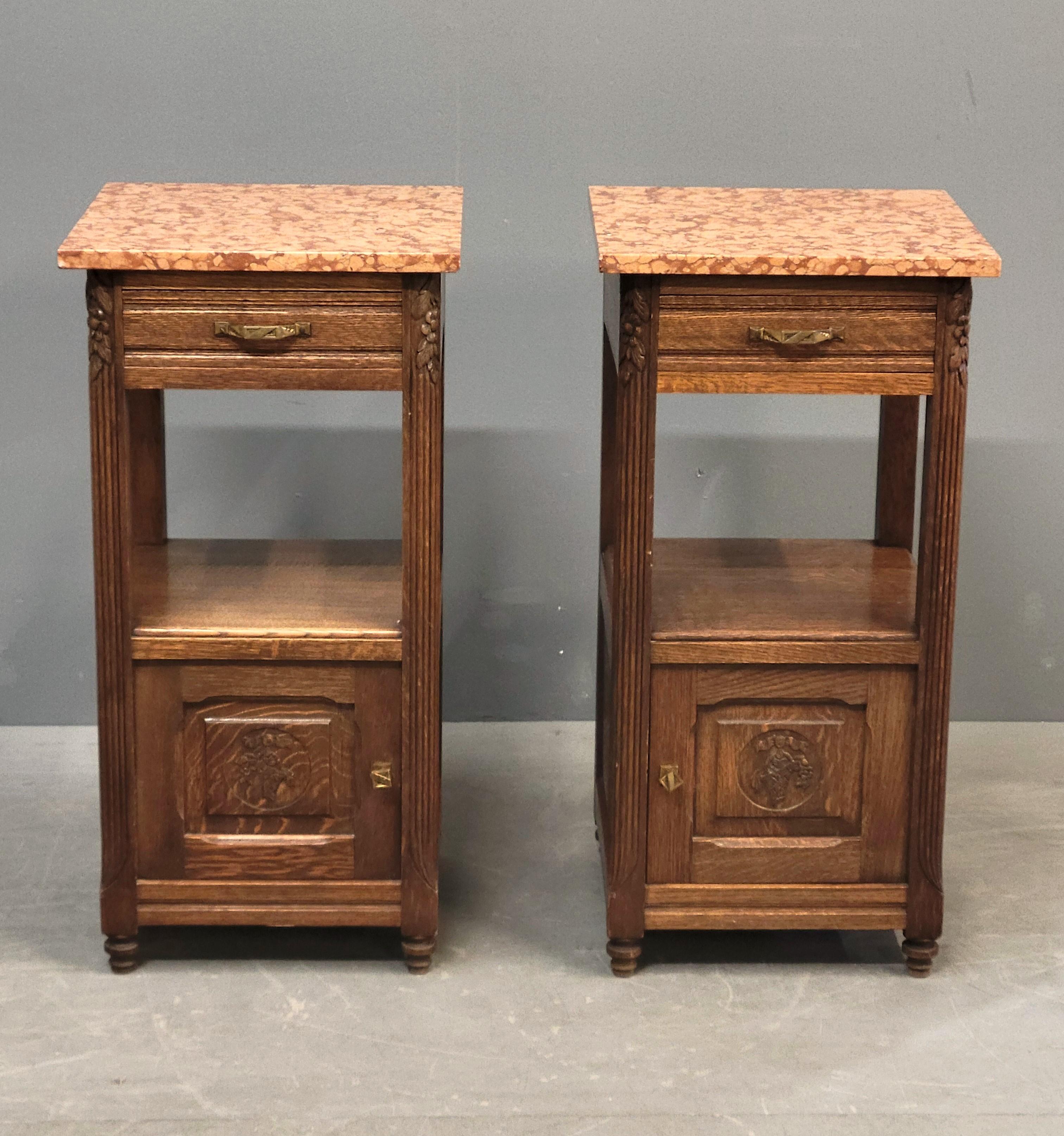 A beautiful and classic pair of antique 1920s European oak pot cupboards, possibly German, with original gorgeous Italian terracotta red marble. Original brass hardware. Carved medallion with cornucopia on the front of each door. Perfect in a small