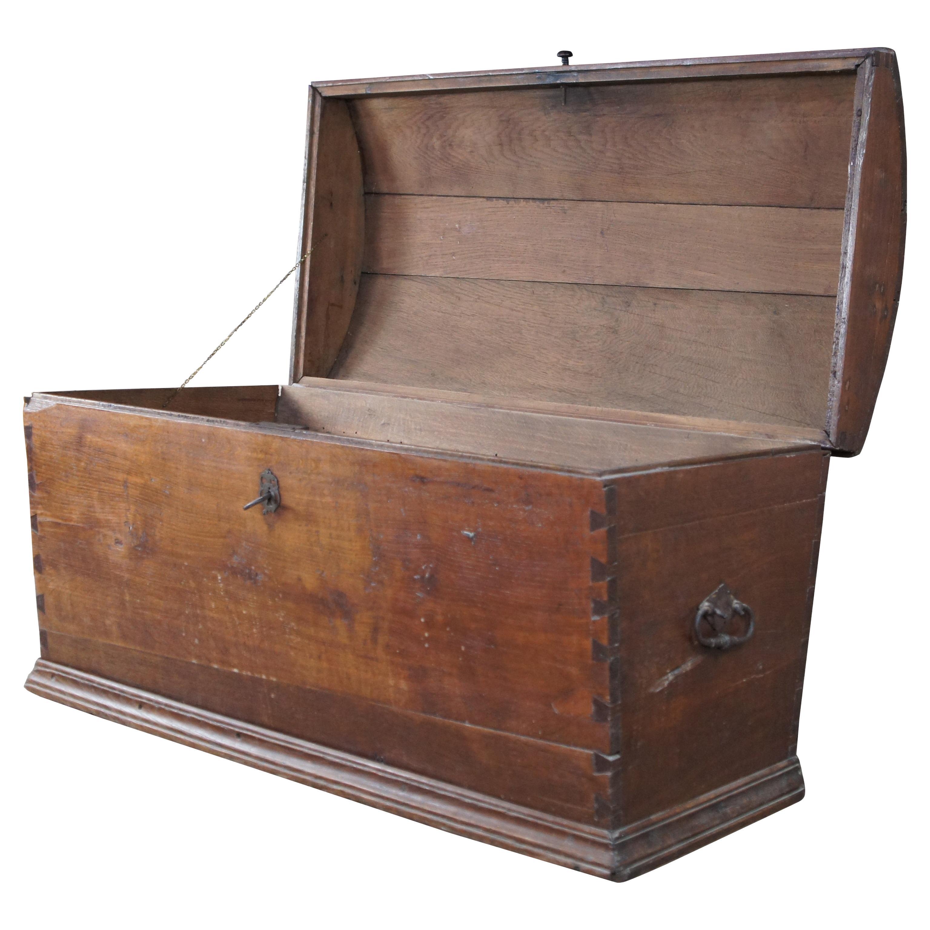 Antique early 19th century oak chest or trunk.  Designed to serve as a container for sea transport, this sea chests features dovetailed joinery with hinged, domed top and iron hardware.  Includes a working lock and key.

Dimensions:
50