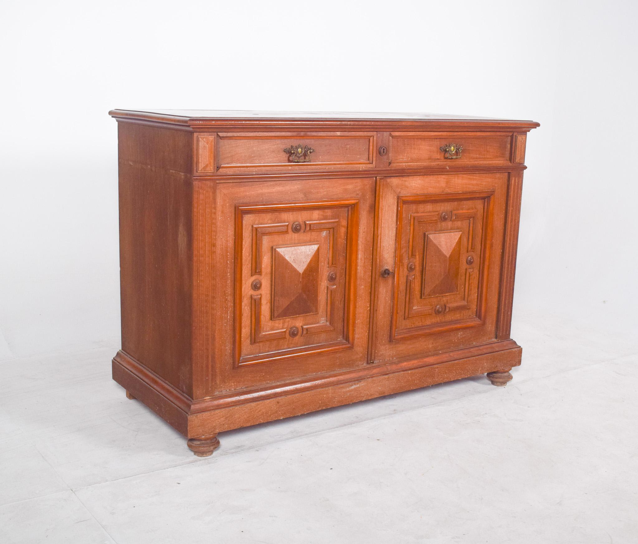 Oak sideboard with padded doors. A beautiful example of traditional joinery with a strong ornamental presence. The two front doors stand out due to the panels carved in relief with geometric patterns, creating depth and an imposing look. Above, two
