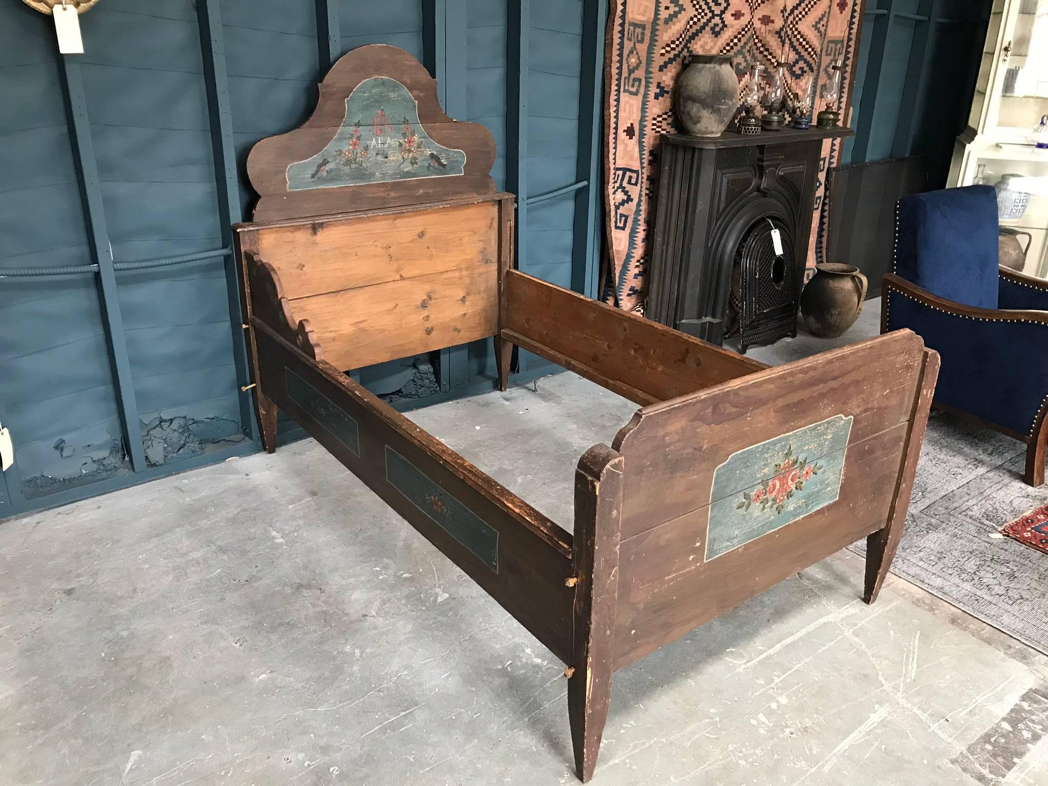 Late 19th century, children's bed frame in oak. Features tapered legs and hand-painted details of roses, birds, and the name 'Ara'.