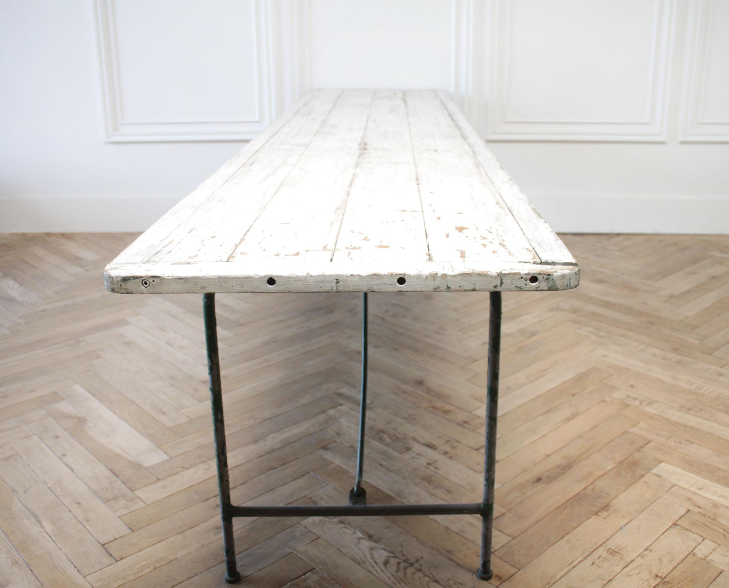 Antique European painted wood folding dining or serving table
White chipping paint exposing a green paint and wood surface.
This table has metal folding legs, that collapse under for easy storage.
Size: 120