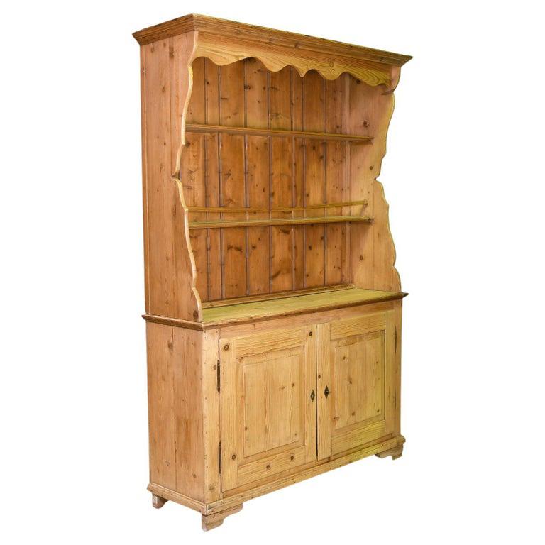 A lovely antique country cupboard in scrubbed European pine with open dish rack that rests on a cabinet with two doors that have raised panels & offers spacious storage. Northern Germany, circa early to mid 1800's. Fabrication consists of lap joint