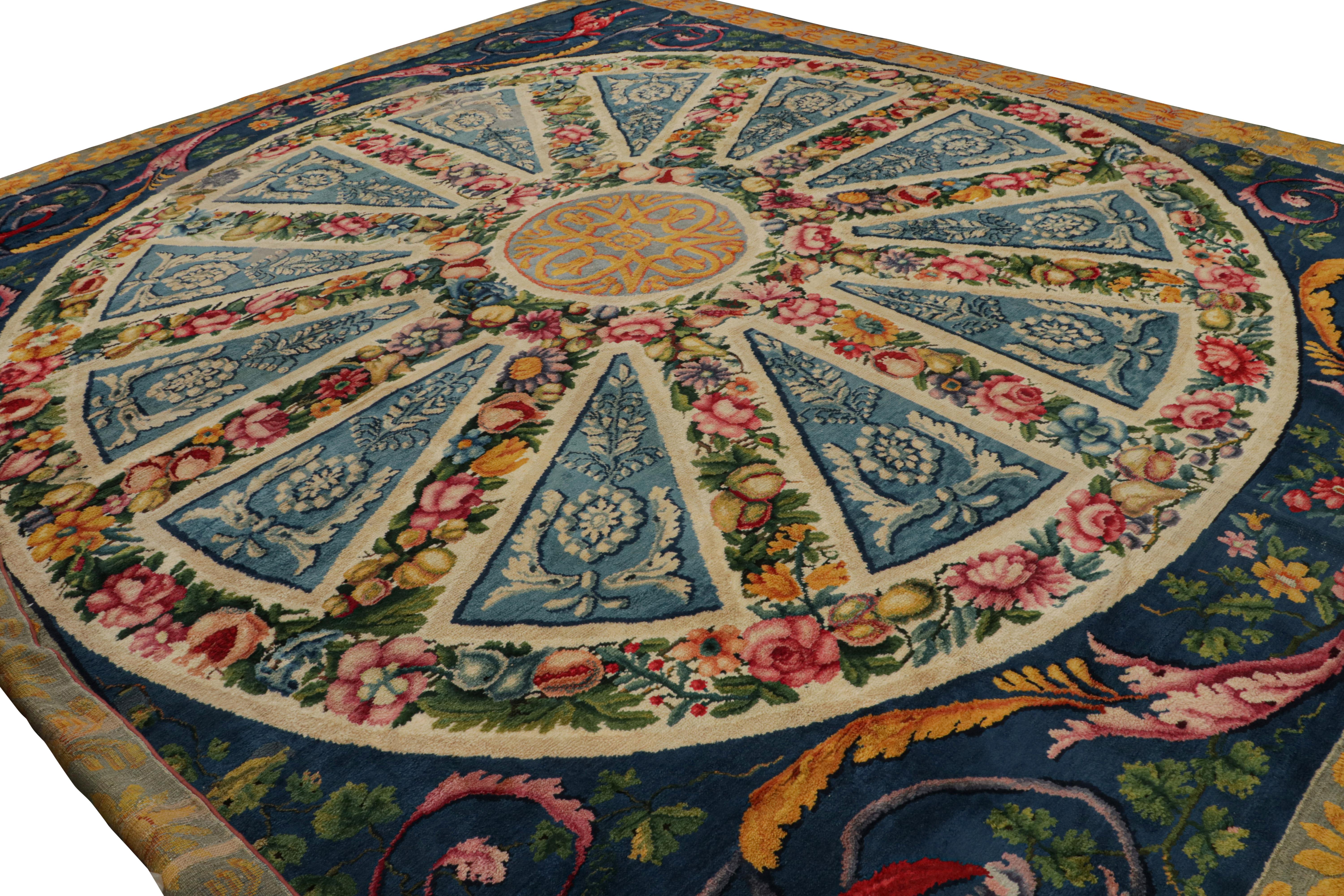 Hand Knotted in wool, this 16x19 European rug hails from a factory that still exists today called “fabrica de Tapices” in Spain, circa early 20th century. This masterpiece is very unique in its emphasis on blue, but the design resembles European