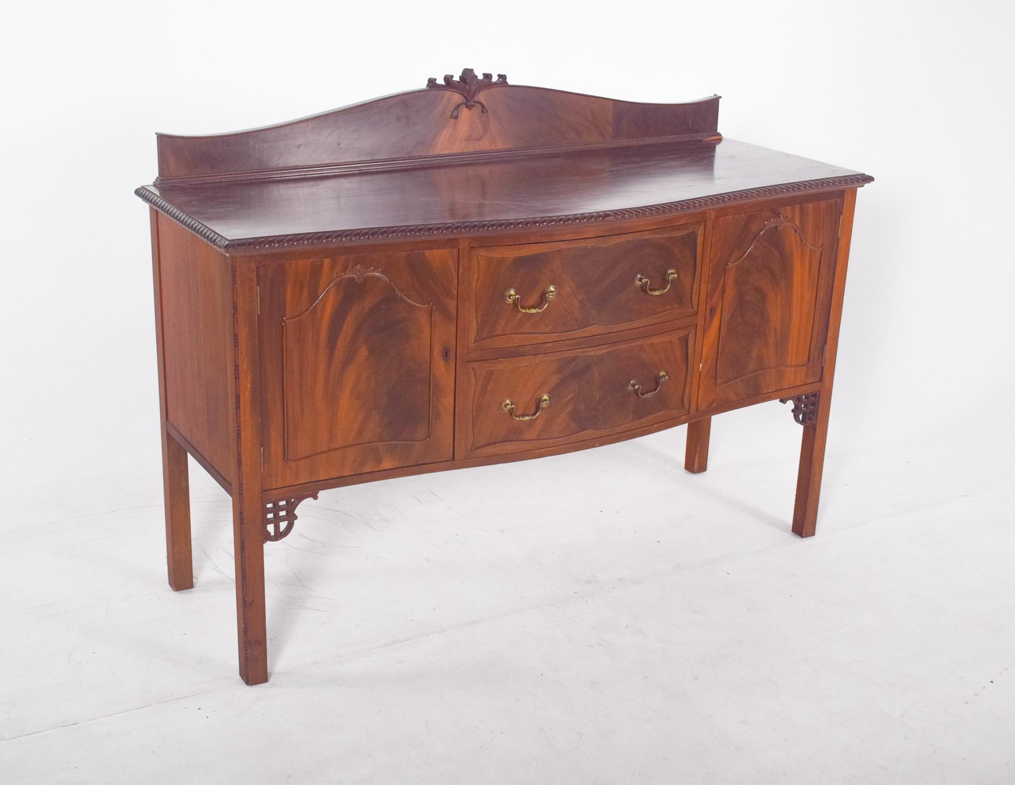 Aparador con una pequeña elevación. Este elegante aparador de madera tiene un diseño clásico y sobrio, caracterizado por la calidad de la carpintería y los discretos detalles decorativos. La estructura rectangular está formada por dos puertas