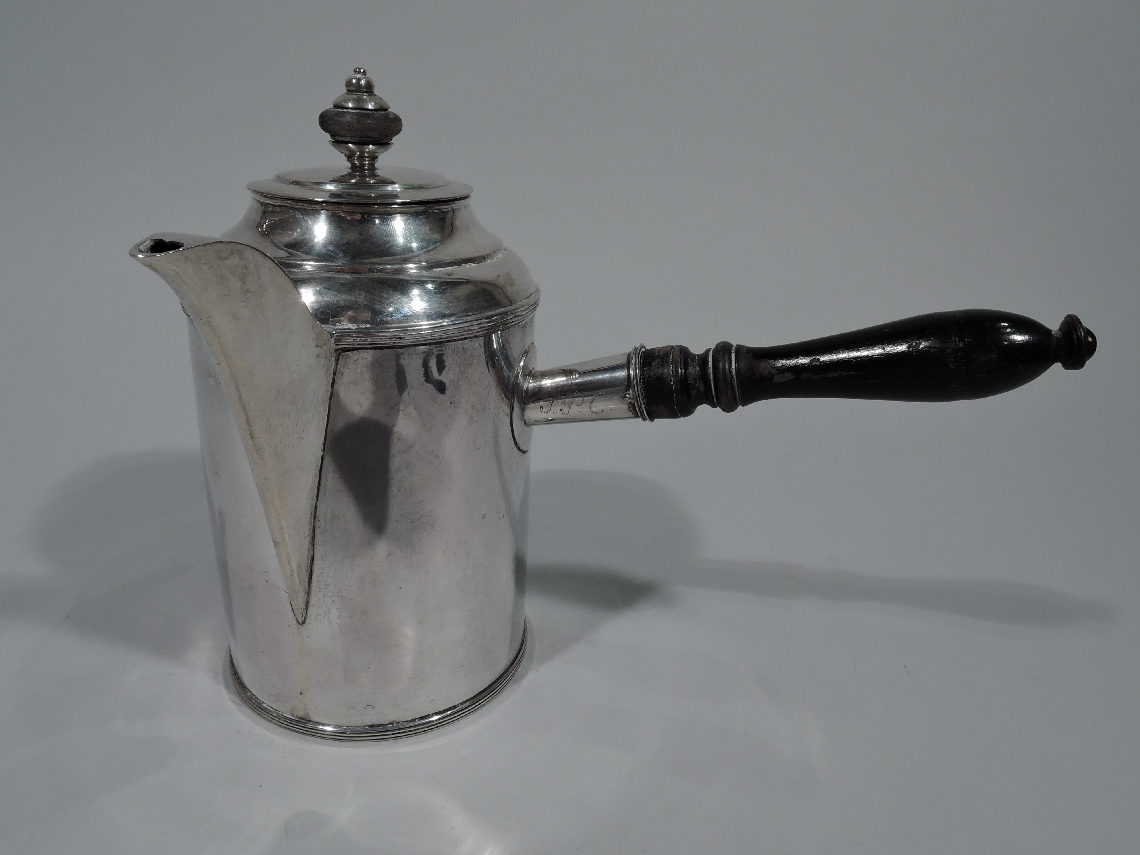 European silver coffeepot, circa 1850. Cylindrical with applied spout, domed shoulder, and stepped cover with stained-wood finial. Stained wood baluster side handle in silver mount with 3-letter pointille monogram. Applied scrolled spout. Reeded