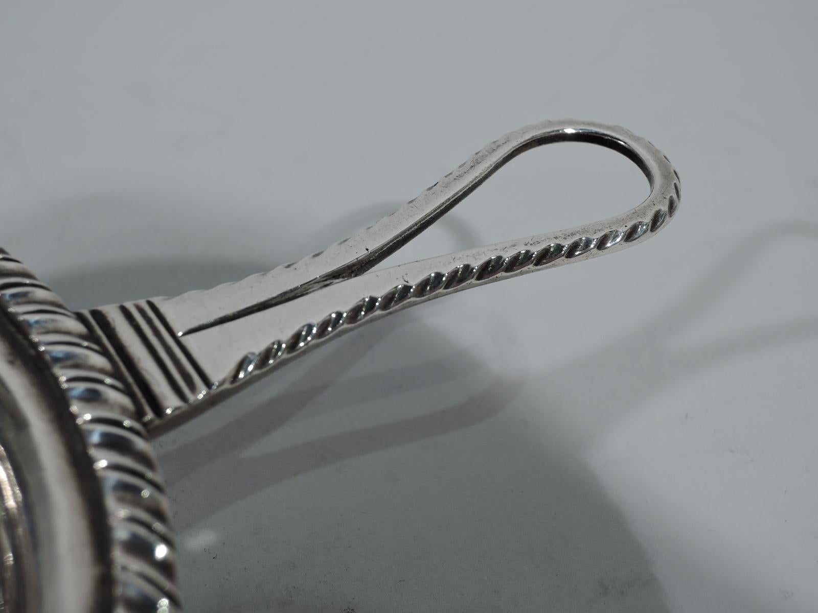 Antique European silver strainer, circa 1840. Round bowl with concentric piercing, gadrooned rim, and feathered open loop handle. On handle back is engraved shaded block monogram NP. Marked. Weight: 5.5 troy ounces.