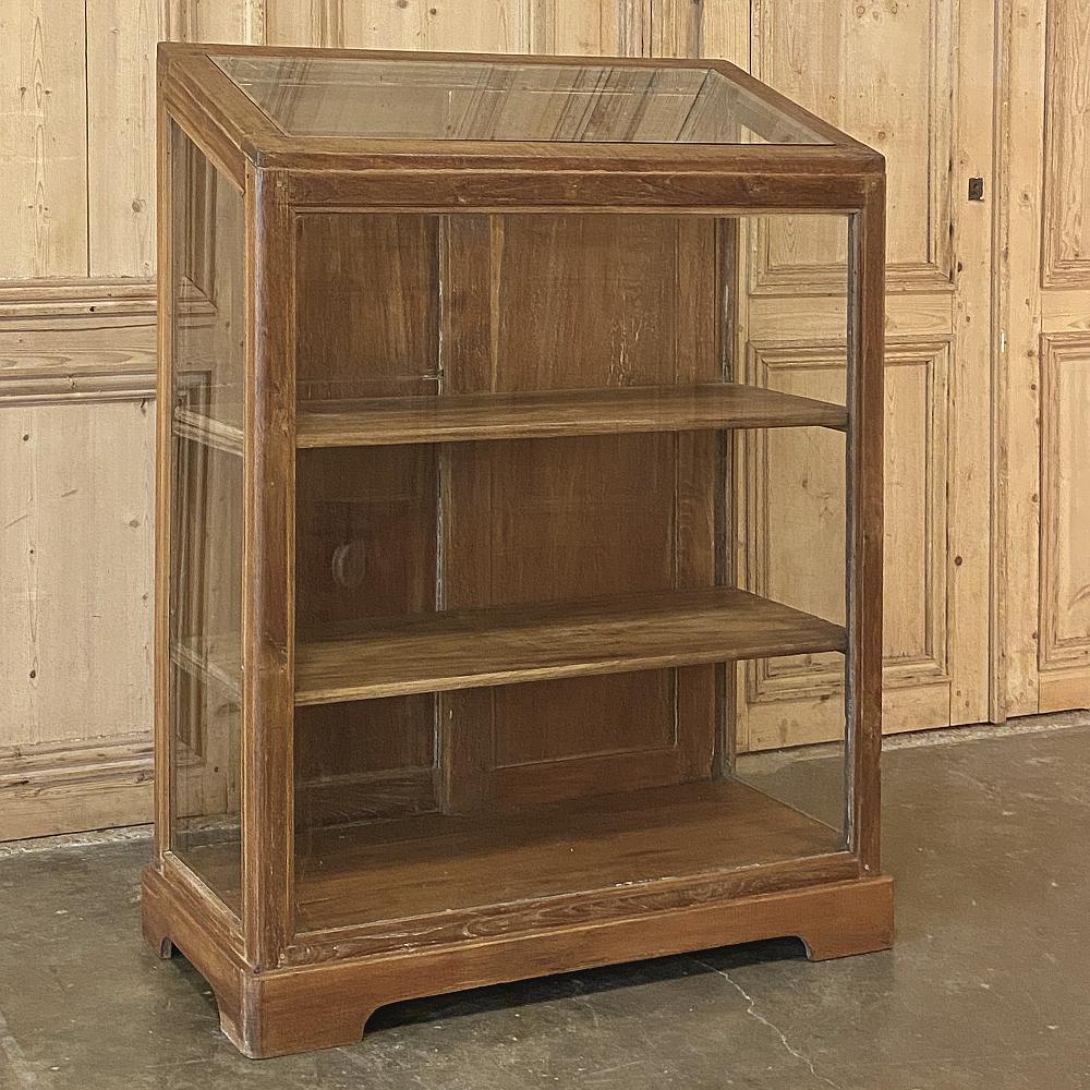 Antique European Slant front store display cabinet is an uncommon artifact from the early 1900s, as such pieces rarely survive the vagaries of time and commerce for such an extended period of time! Handcrafted from walnut, it features three surfaces