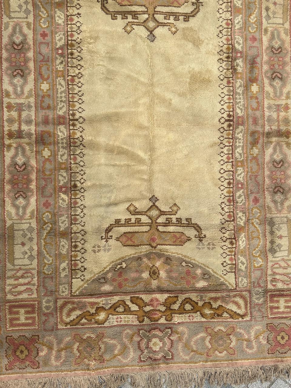 Pretty Early 20th century Spanish hand knotted rug, with a design of antique Turkish Oushak rugs, with stylized geometrical designs and symbols and nice light colours with a light yellow background and pink, grey, green, yellow and brown, entirely