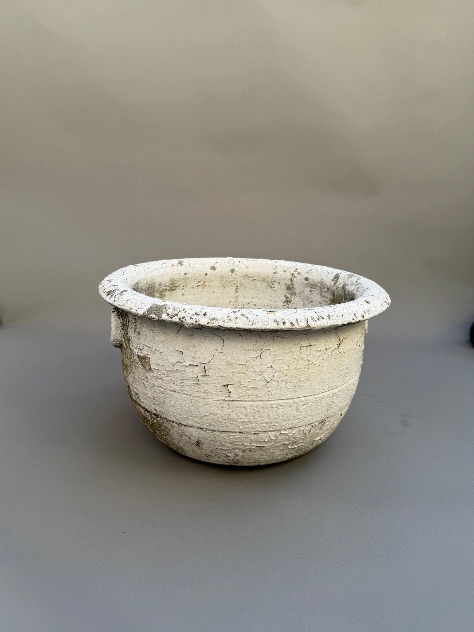 Une jardinière en terre cuite européenne antique magnifiquement vieillie, avec une patine blanche gracieusement altérée par le temps. Cette pièce intemporelle dégage un charme rustique avec sa silhouette arrondie classique, son large rebord roulé et