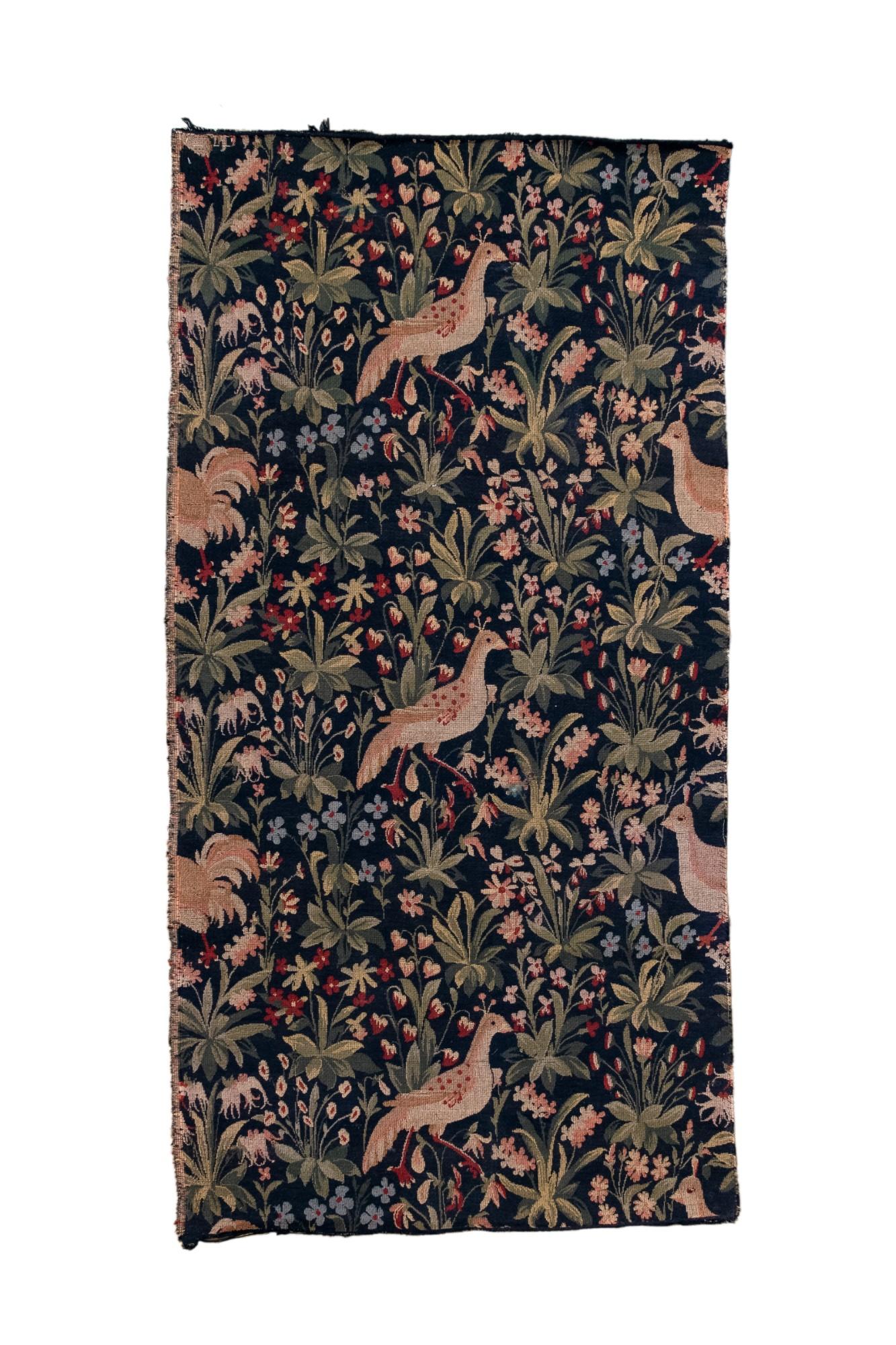 Dieser wunderschön detaillierte Wandteppich zeigt ein lebhaftes, sich wiederholendes Muster aus stilisierten Vögeln inmitten von üppigem Laub, blühenden Blumen und belaubten Zweigen. Auf einem Feld in tiefem Marineblau gewebt, zeigt das Dessin