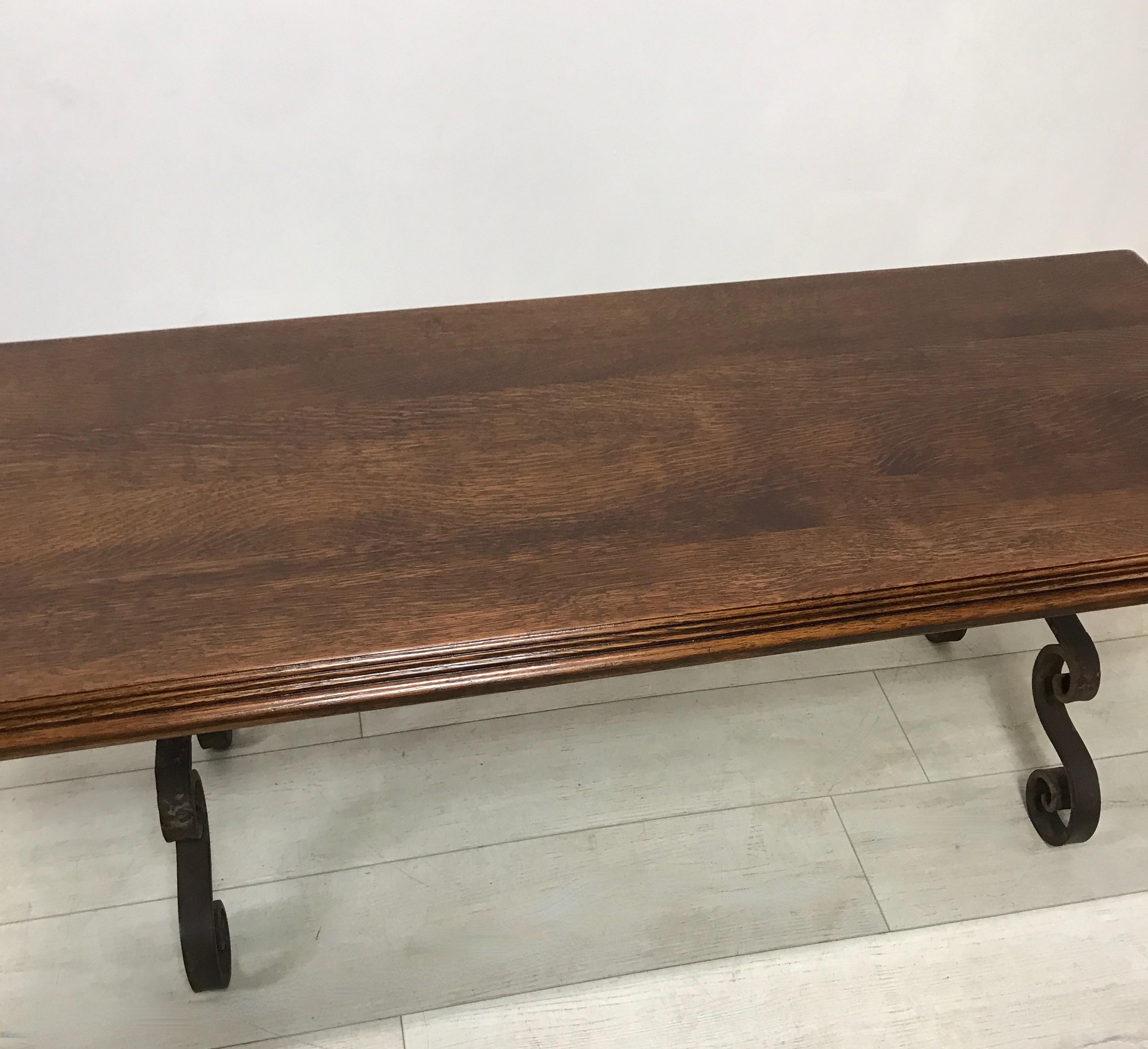 Wrought iron and oak coffee table or bench. 
Iron work base appears to be 18th century or earlier cut down to the present height, with a later early to mid 20th century oak top.
Iron likely of Spanish or Italian origin.
Recently refinished.