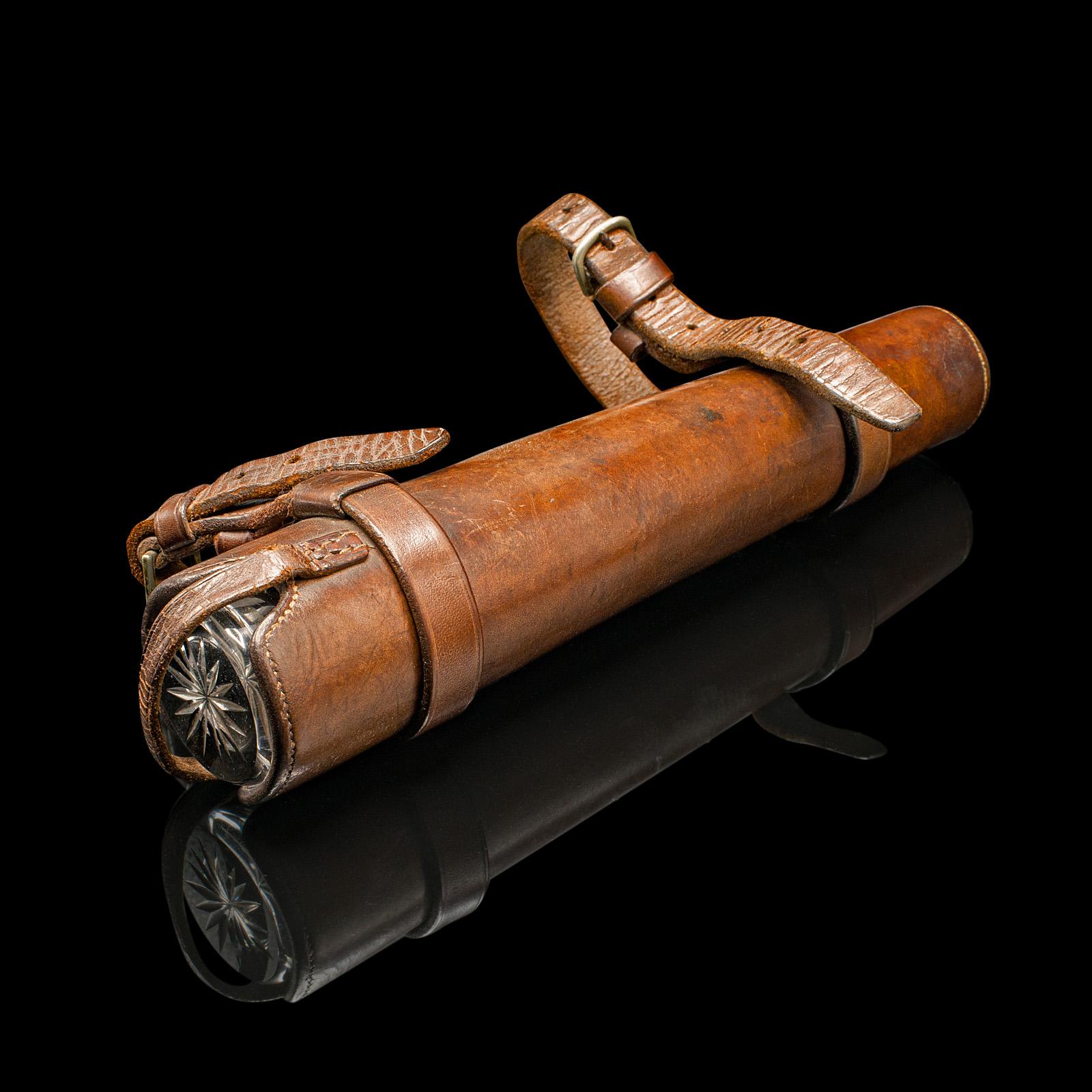 This is a  superb antique explorer’s saddle flask, crafted in England during the Edwardian period, circa 1910. This charming glass and silver plated riding bottle is housed in its original leather carry case, designed for stylish explorers and