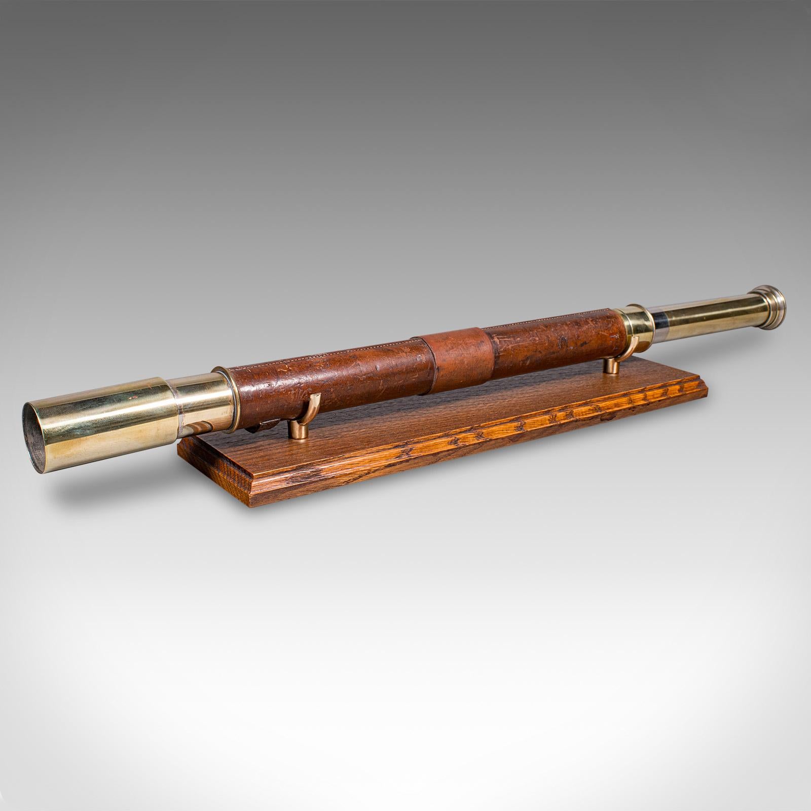Questo è un antico telescopio da esploratore. Un cannocchiale inglese, terrestre o marittimo, risalente al periodo edoardiano, circa 1910. Con la sua classica forma a estrazione singola, gli accessori in ottone e il rivestimento in pelle, questo