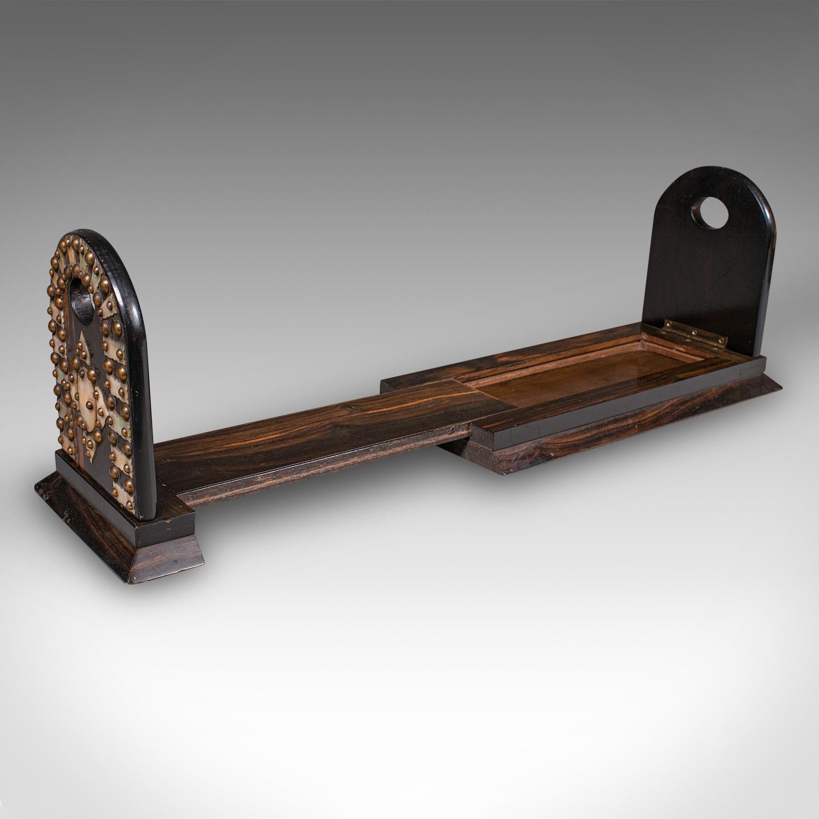 This is an antique extending book slide. An English, coromandel novel rest dating to the Regency period, circa 1830. A piece of both practical function and refined elegance, it is a superb addition to any home library or reading nook.

Crafted from