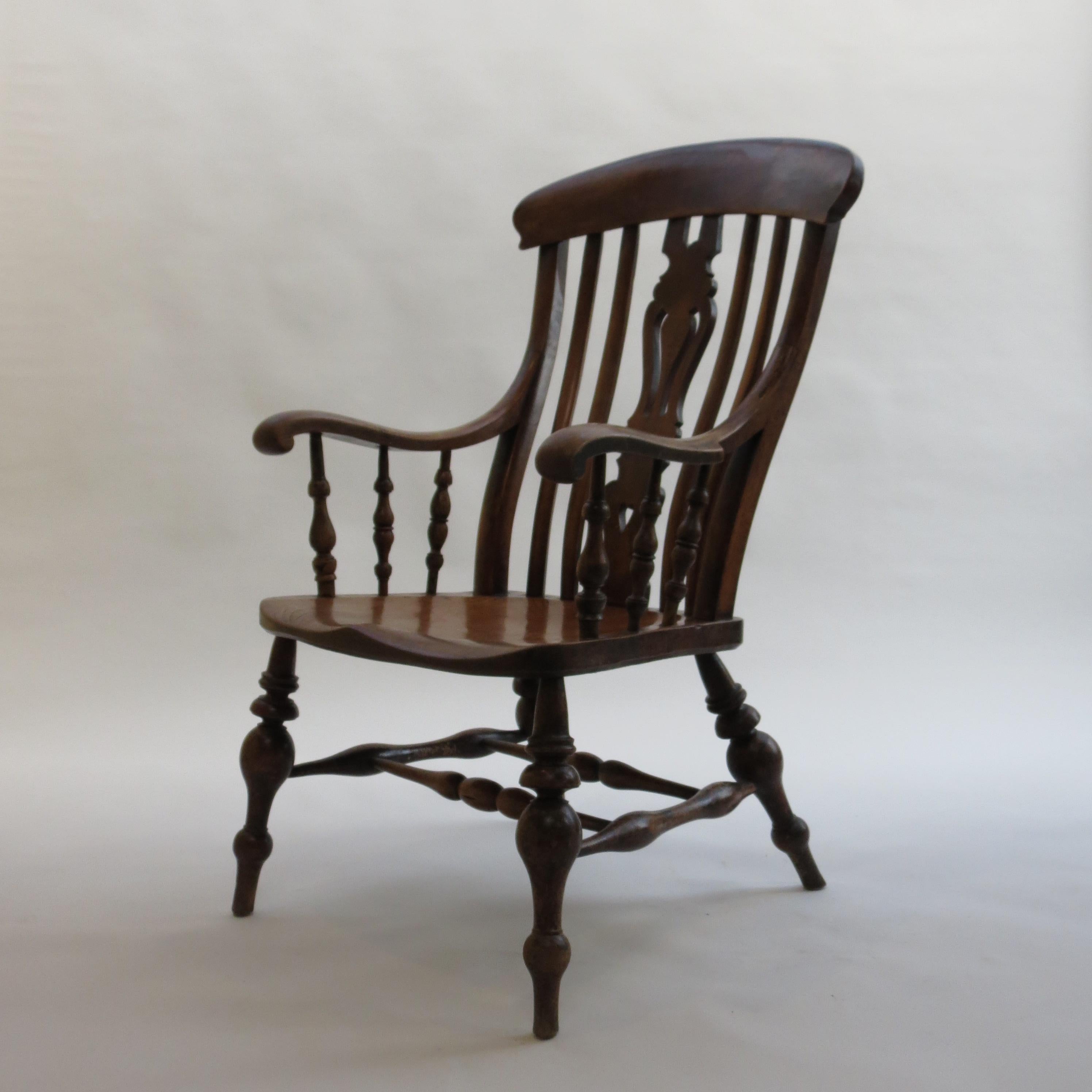 A very large English country Windsor chair from the 19th Century.  

Very large proportions, wonderful turned bulbous legs and double stretcher detail.  Sycamore arms and back rest, large Ash Seat. Dates from the 1880s.
The wood is wonderfully
