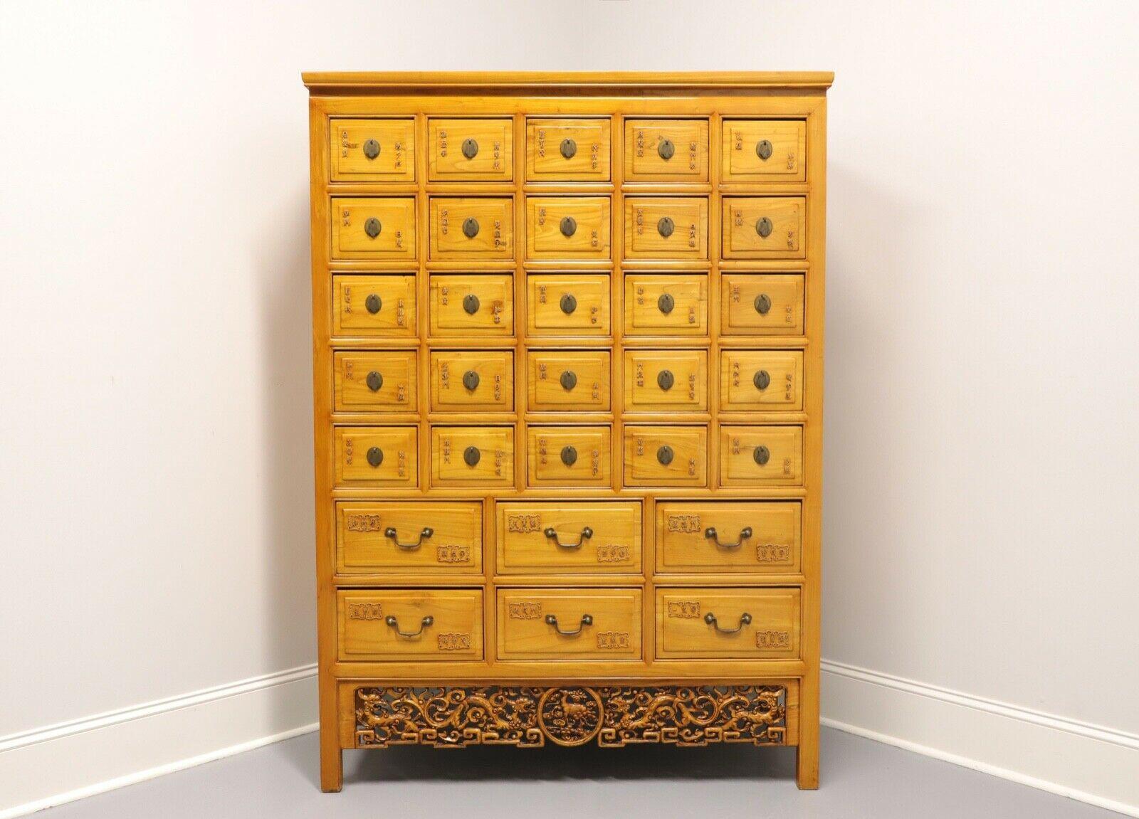 An antique Chinese apothecary / medicine / herbal cabinet, unbranded. Large and impressive. Elm wood with brass hardware, decoratively carved Chinoiserie filigree apron and straight legs. Features twenty-five 8 W x 5 H smaller drawers over six 14 W