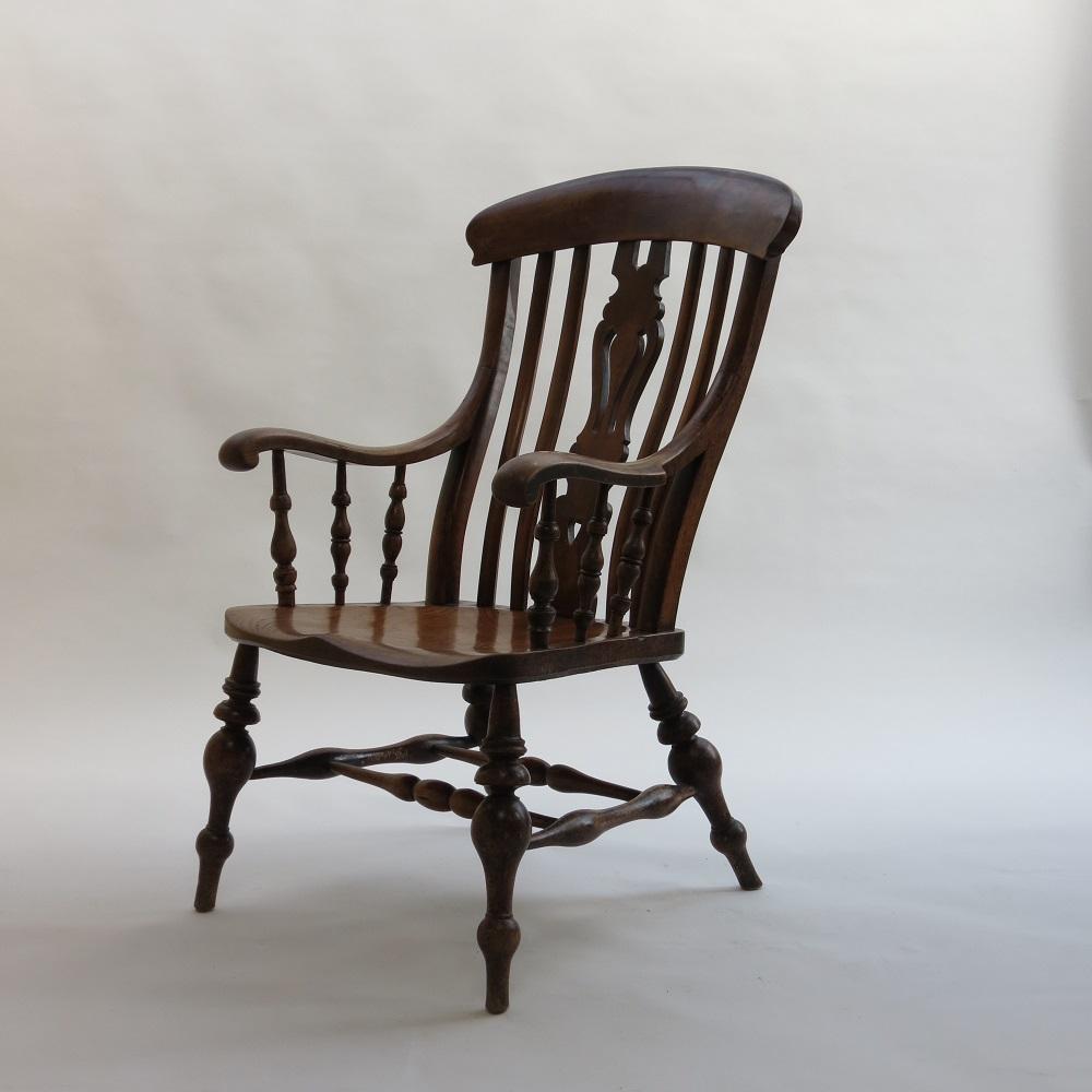 A very large English country Windsor chair from the 19th Century.  

Very large proportions, wonderful turned bulbous legs and double stretcher detail.  Sycamore arms and back rest, large Ash Seat. Dates from the 1880s.
The wood is wonderfully