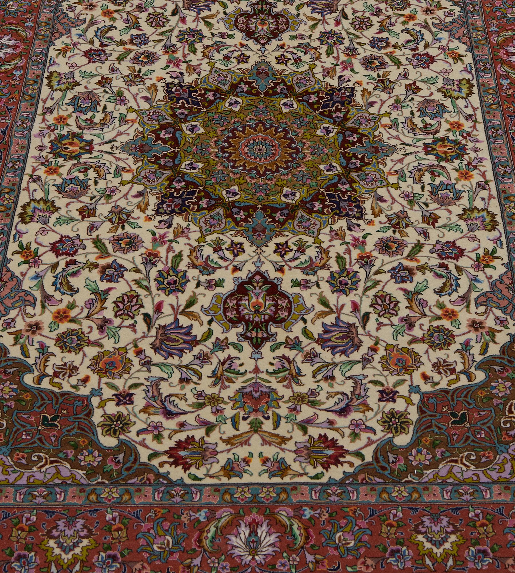 This vintage, circa 1980, extremely fine wool and silk Tabriz rug has an ivory field with a delicate polychrome scrolling palmette and floral leafy vine around a central medallion with palmette pendants containing a lime-green panel with a