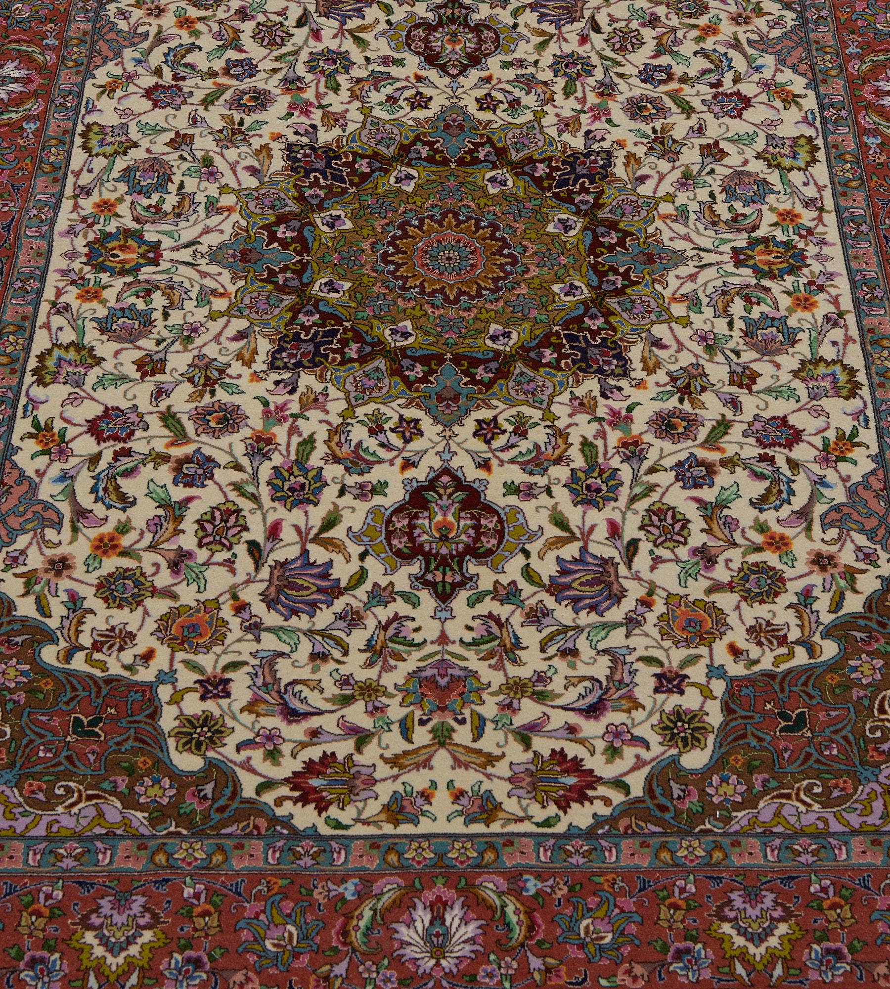 Ce tapis Tabriz vintage, vers 1980, en laine et soie extrêmement fine, a un champ ivoire avec une délicate palmette à enroulement polychrome et une vigne feuillue florale autour d'un médaillon central avec des pendentifs de palmettes contenant un