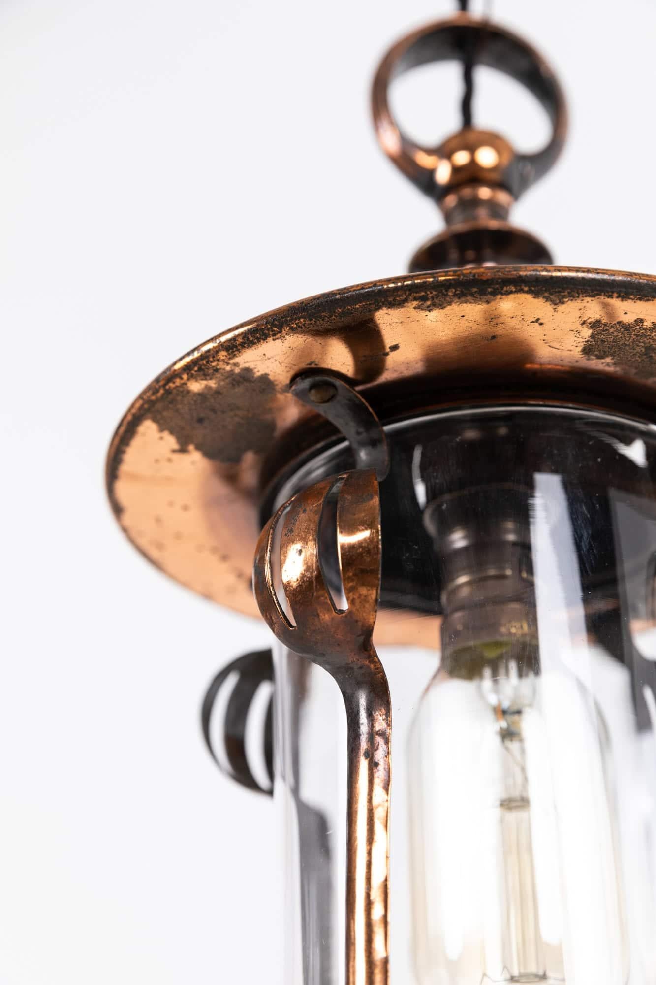 

A beautifully formed copper porch lantern made by F&C Osler. c.1910

In the Arts & Crafts style, oxidised copper on brass with the large hanging loop and hand blown and rolled glass insert. Original decorative ceiling rose present, stamped