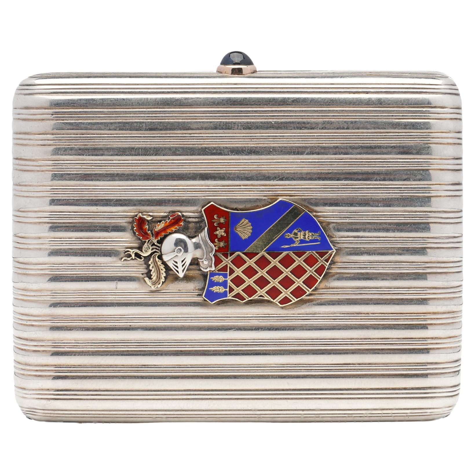 Antique Fabergé parcel-gilt silver cigarette case with coat of arms by workmaster August Hollming.
Manufacturer: Fabergé 
Maker: August Hollming.
Made in Russia, St. Petersburg Ca. 1900's 
Fully hallmarked.
Clasp set with Cabochon Sapphire.