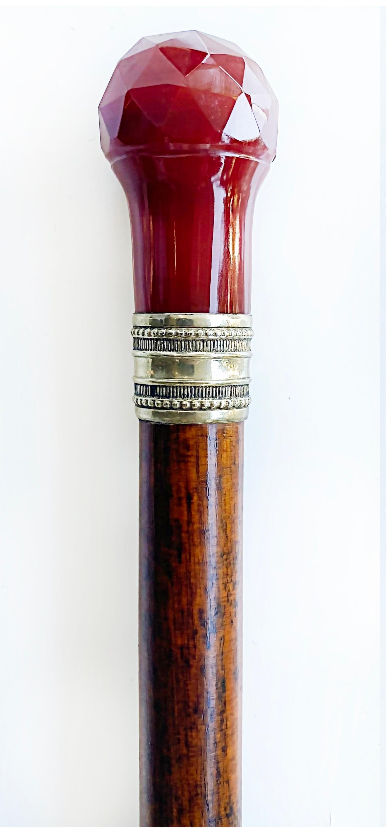 Antique Faceted Carnelian and Silver Banded Walking Stick 

Offered for sale is an antique wooden walking stick with a carved and faceted carnelian top. The handle is attached to the cane with silver banding. The tip of the cane is silver also. We