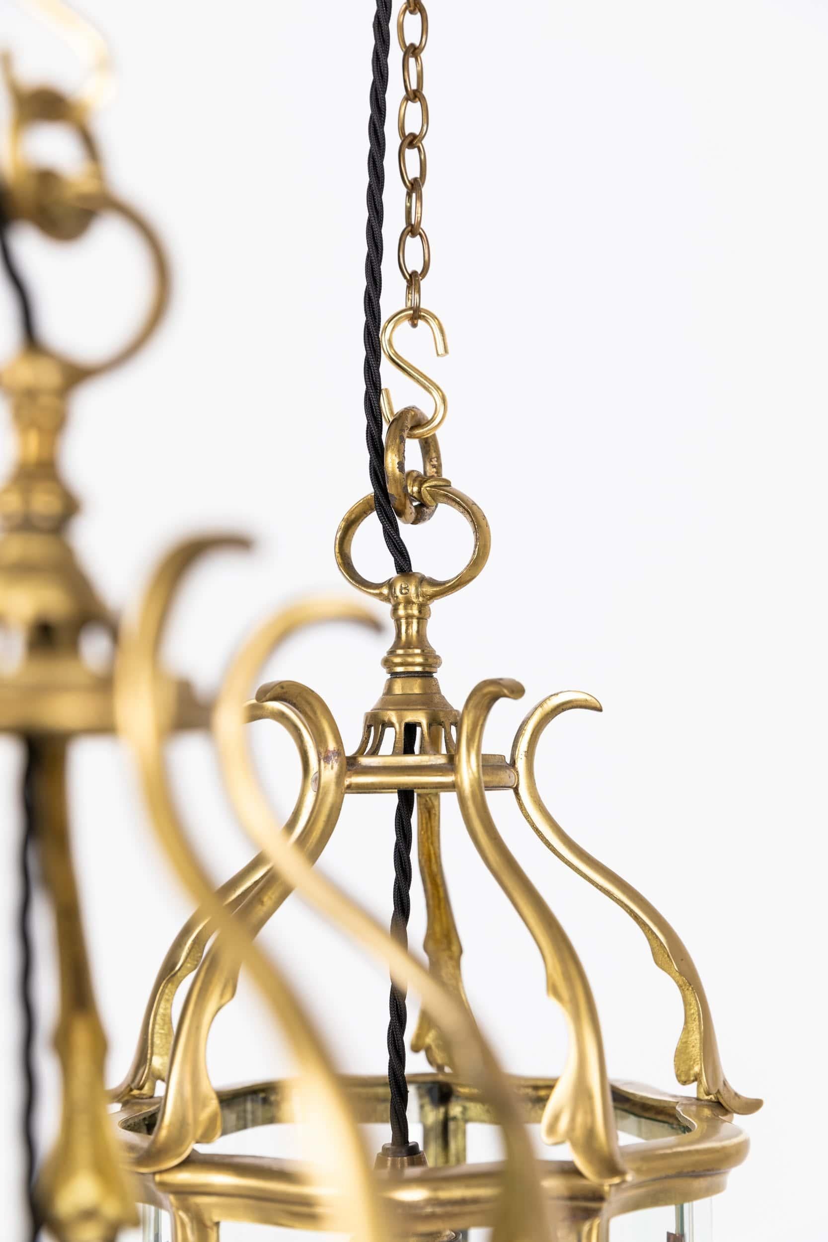 A beautifully formed brass porch lantern made by Faraday & Son. c.1920

Crafted from brass to the highest standard. Curved glazed panels all original and intact. One lantern faintly stamped F&S to the brass above one glass panel and hanging loop.