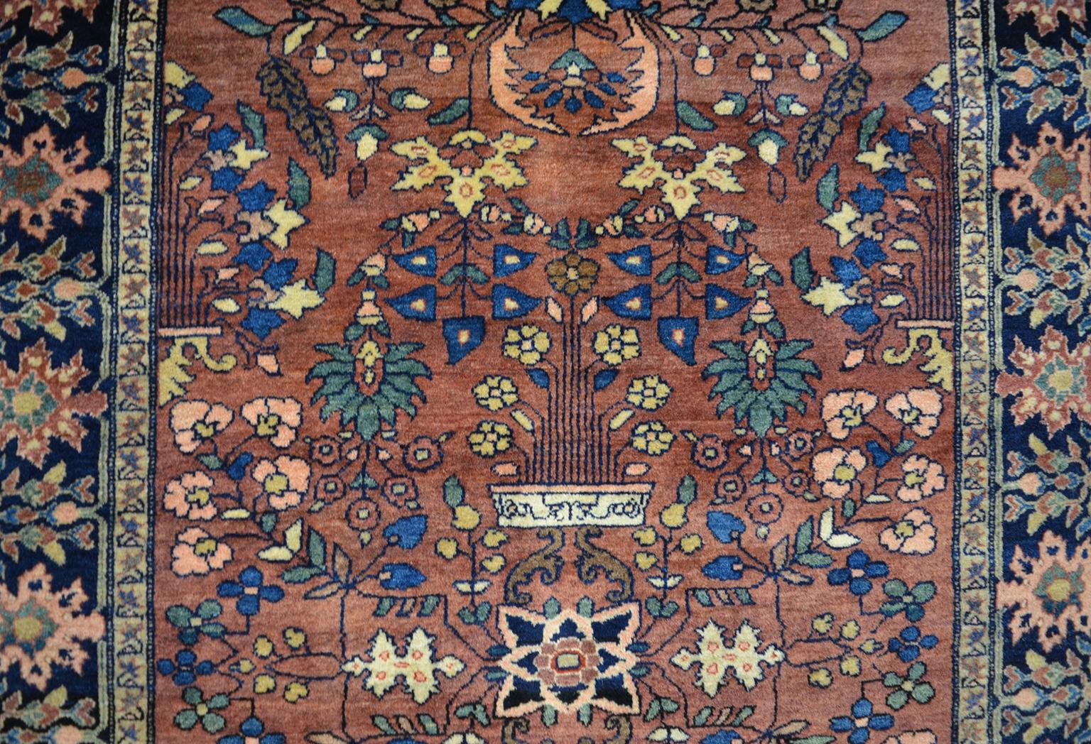 This antique Farahan Persian carpet circa 1880 in pure handspun wool and organic vegetable dyes showcases a Classic Sarouk design in rich blues and navy, red, gold and light pink. Stylized floral motifs decorate the border and field in a symmetrical