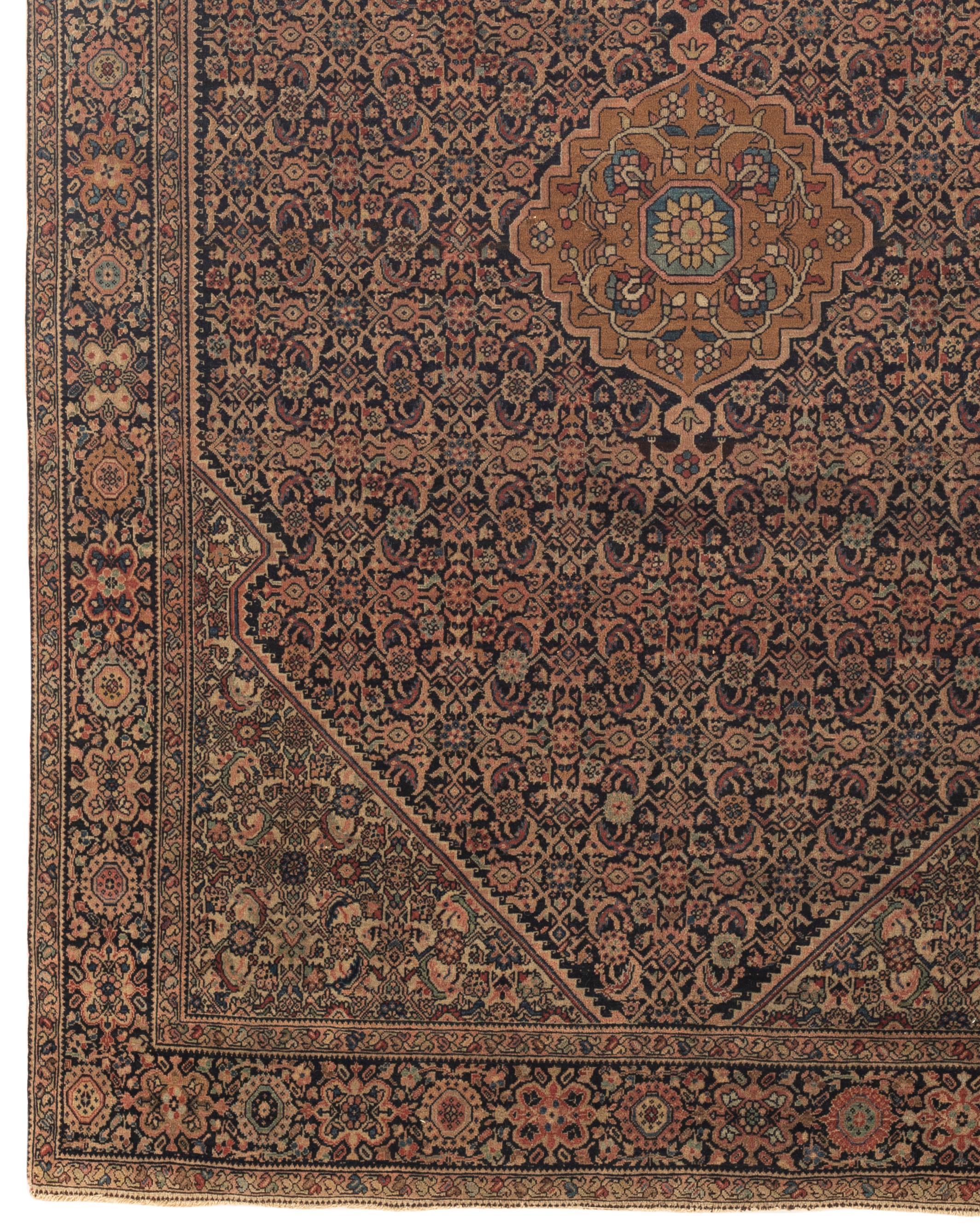 Antique Farahan Sarouk rug, circa 1880. Sarouk rugs come from west central Persia. On a navy field and border this rug expresses strength and style with its detailed floral designs scattered over the entire piece creating a wonderful visual setting