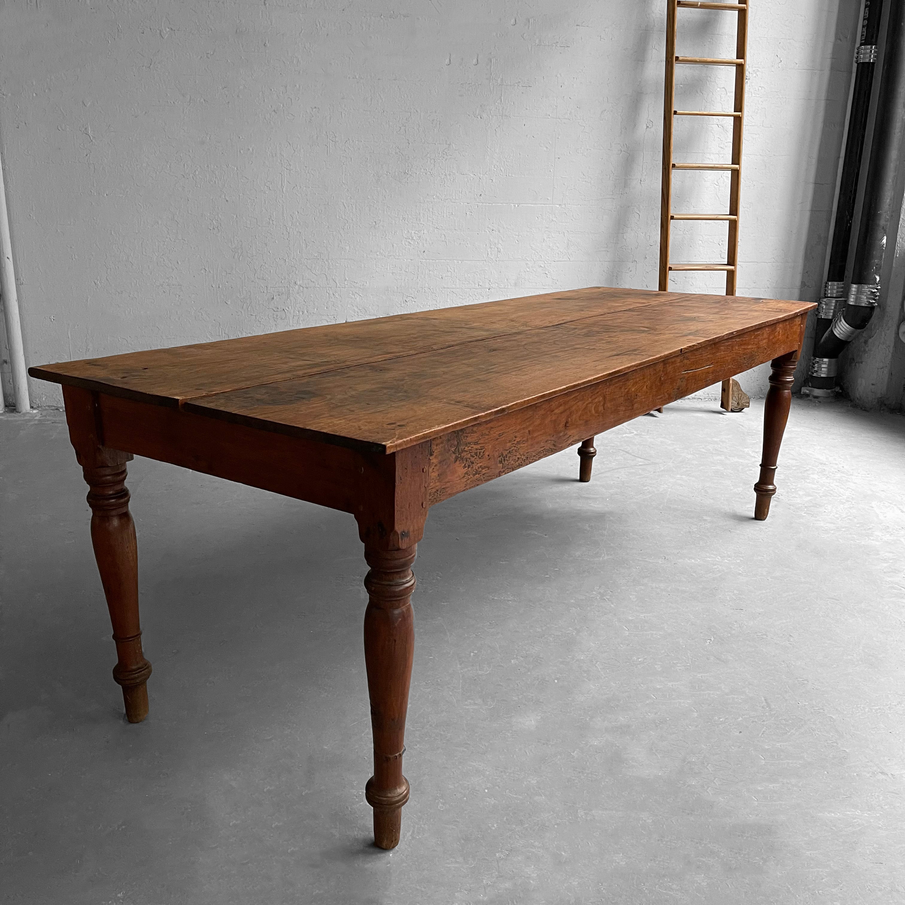 Antique, English walnut, farm table features turned legs with wide plank top. The table is sturdy and weathered beautifully for a stately rustic look. Height to the lip is 24 inches. The table works wonderfully as a desk, dining or work table.