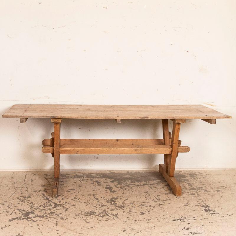 The trestle base of this farmhouse table has a strong visual appeal due to the unusual 