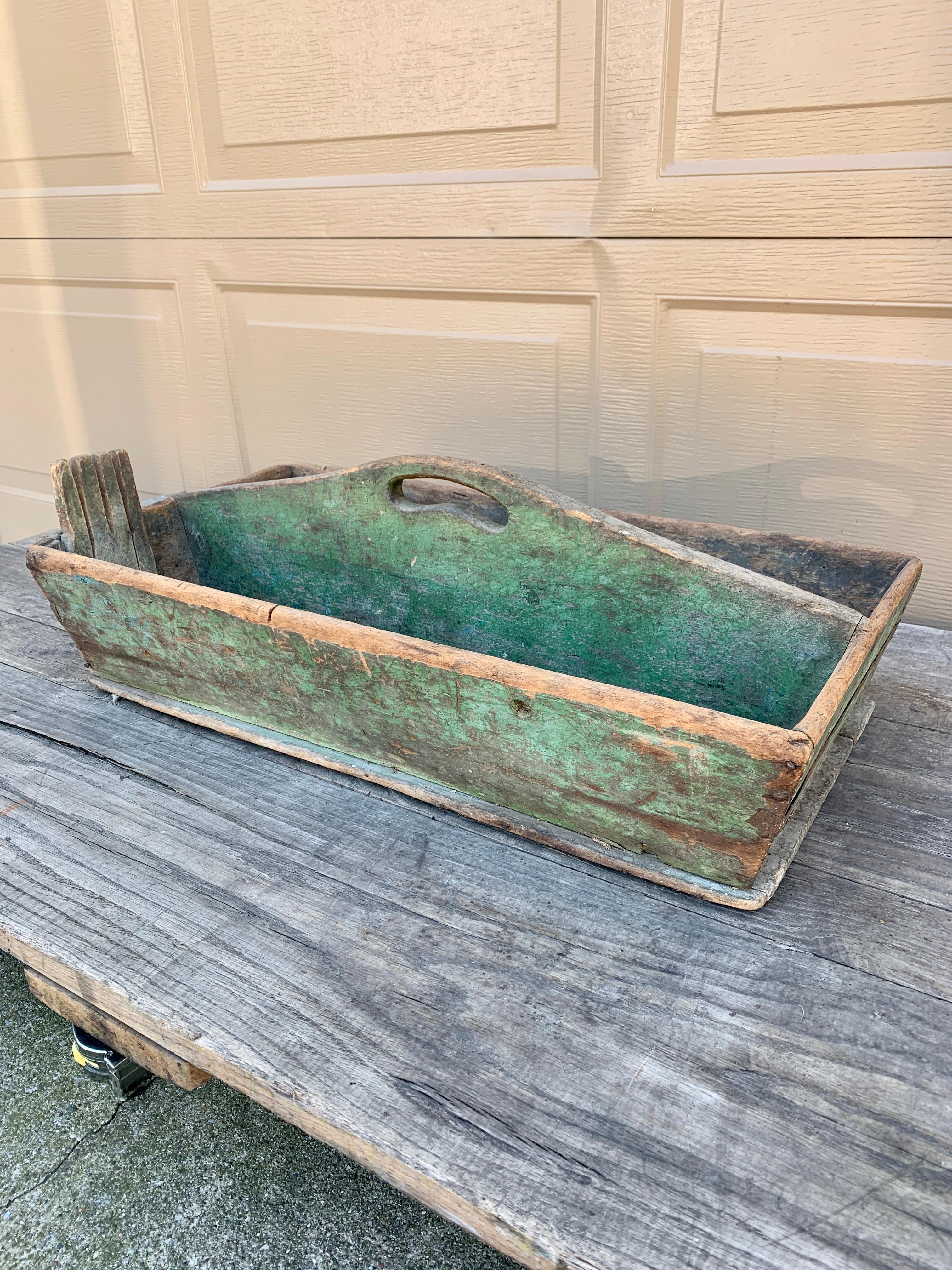 A charming country farmhouse wooden tool box trug painted in a beautiful green. This piece would be ideal as a craft organizer, silverware holder, or garden tool box.

USA, Early 20th Century

Measures: 26.75