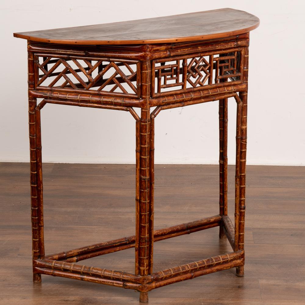 Lovely faux bamboo side table with intricately designed skirt which creates visual intrigue. Demi-lune, half circle shape with rich patina.
Solid, stable condition. Any scratches, cracks, dings, or age related separation (see close up of top) are