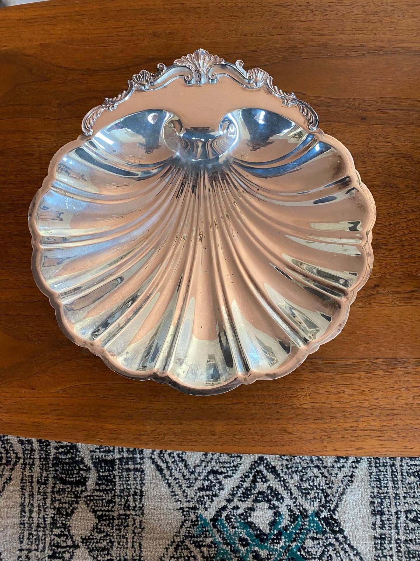 Vintage and luminous footed dish that exudes glamour.  This beautiful vintage piece is silver plated and the patinated.  The dish is sculptural as it stands on 3 footed shells underneath adding style and evoking an era were glamour lived in all