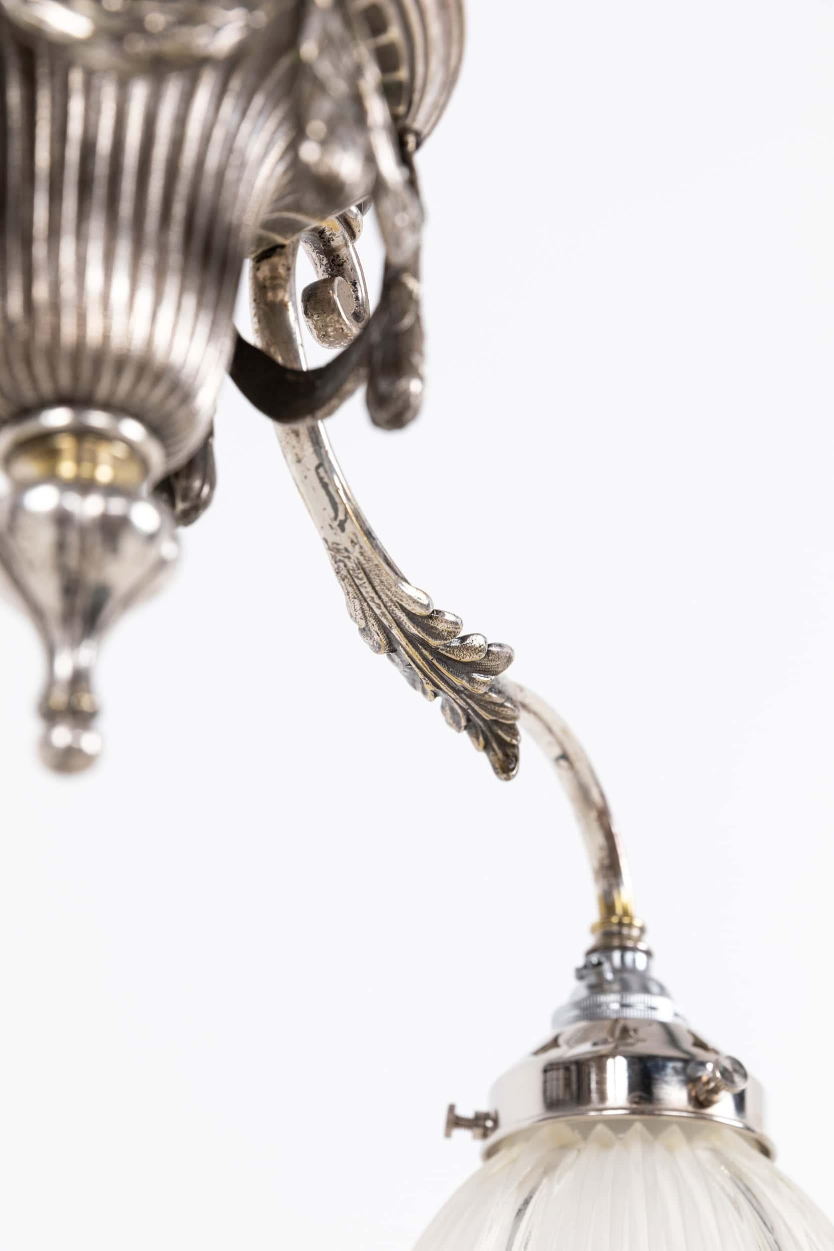 

A beautifully formed rise and fall ceiling light with Holophane glass shades. c.1910

Of exceptional quality and although unstamped, very likely made by F&C Osler. Silver plated brass construction throughout with a matched pair of early Holophane