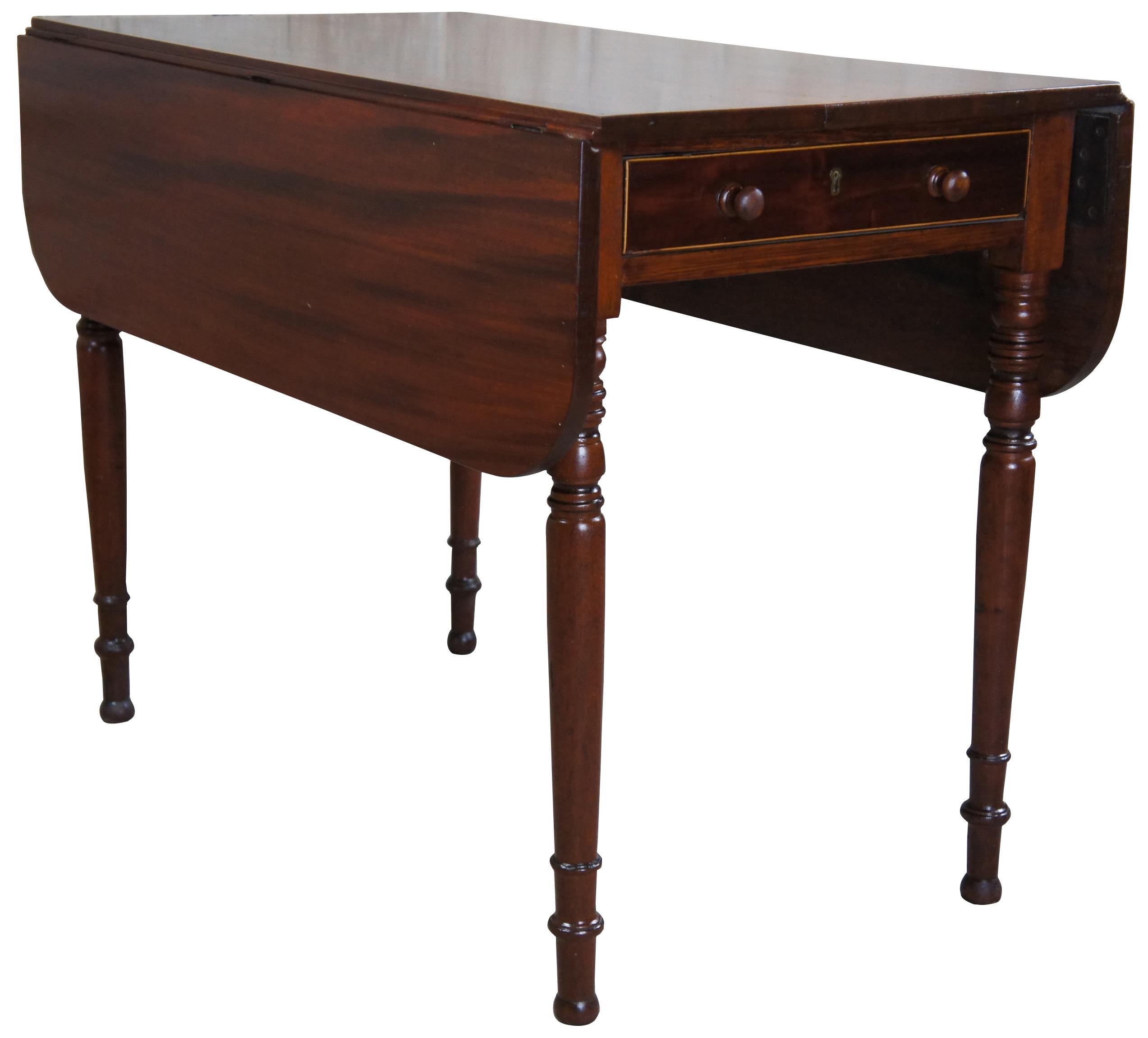 Early 19th century Federal drop leaf dining table. Made from mahogany with hand dovetailed and inlaid drawer over turned and tapered legs. Measure: 39