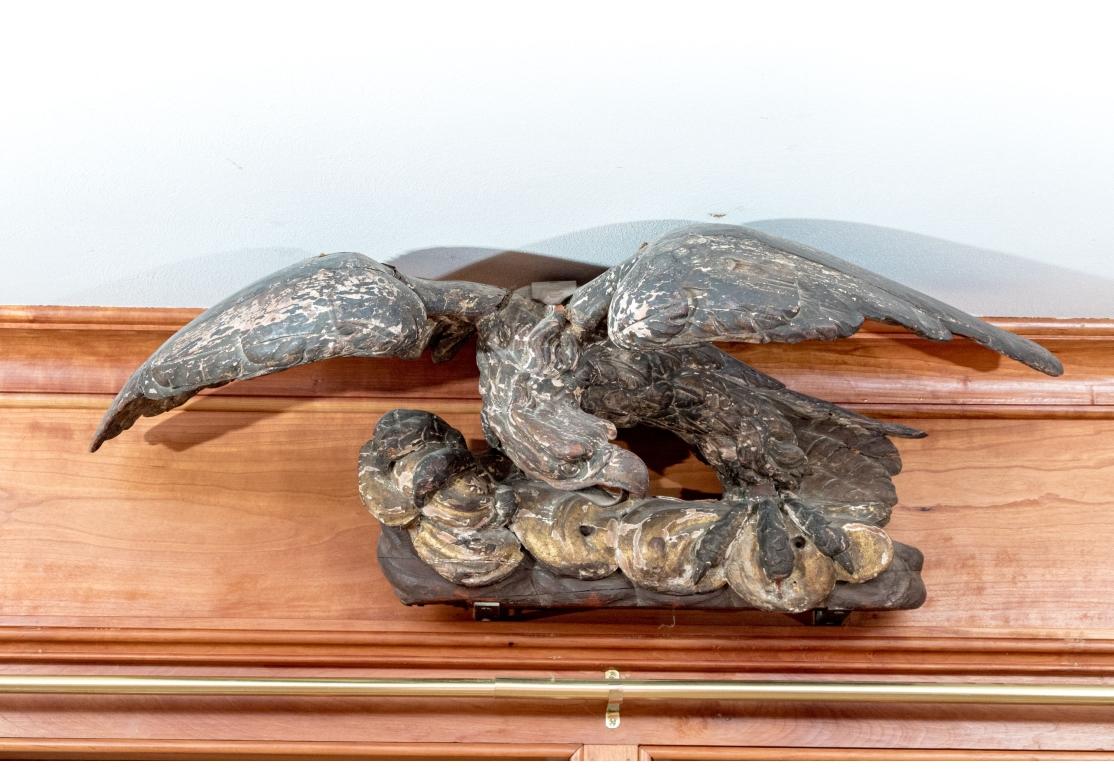 A fine Federal Period carved and gilt Eagle with strong carving, classic form and protective stance. The eagle with wings spread and its head turned to the left. The lower beak is a shaped Iron strap and it is believed that the Eagle may have once