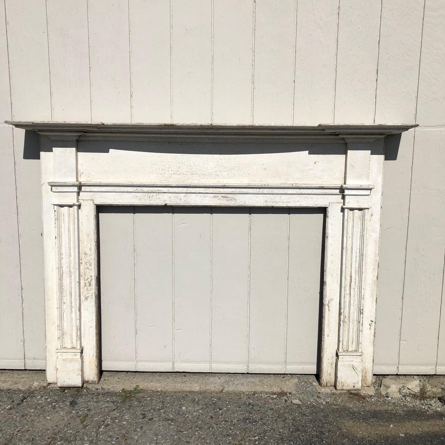 Immaculate late 18th century American carved mantel, probably New Hampshire, having several layers of hand planed crown moldings, unusually intricate and lovely , and showing good detailed carving. There are reeded fluted mantel legs between upper