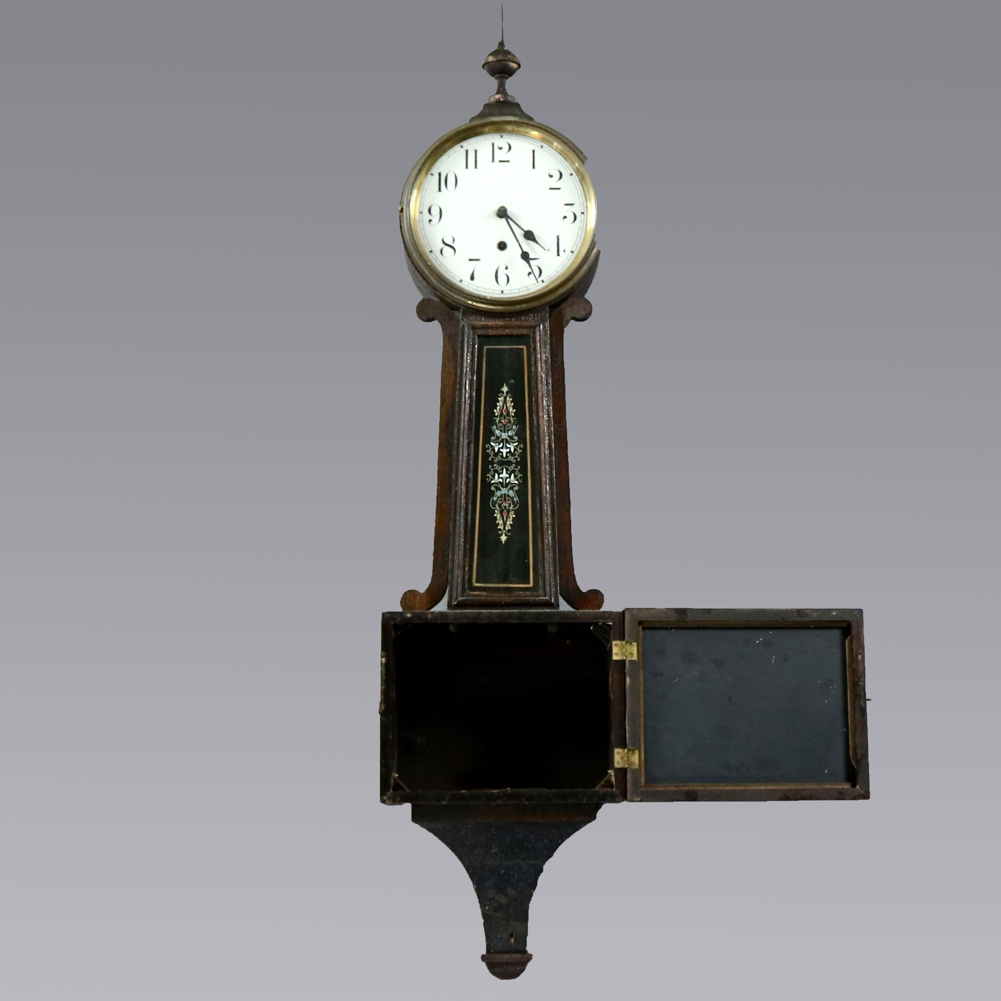 An antique Federal banjo clock by Waterbury offers mahogany case with reverse painted glass panels, original label as photographed, complete with pendulum and key, circa 1900

Measures: 42.75