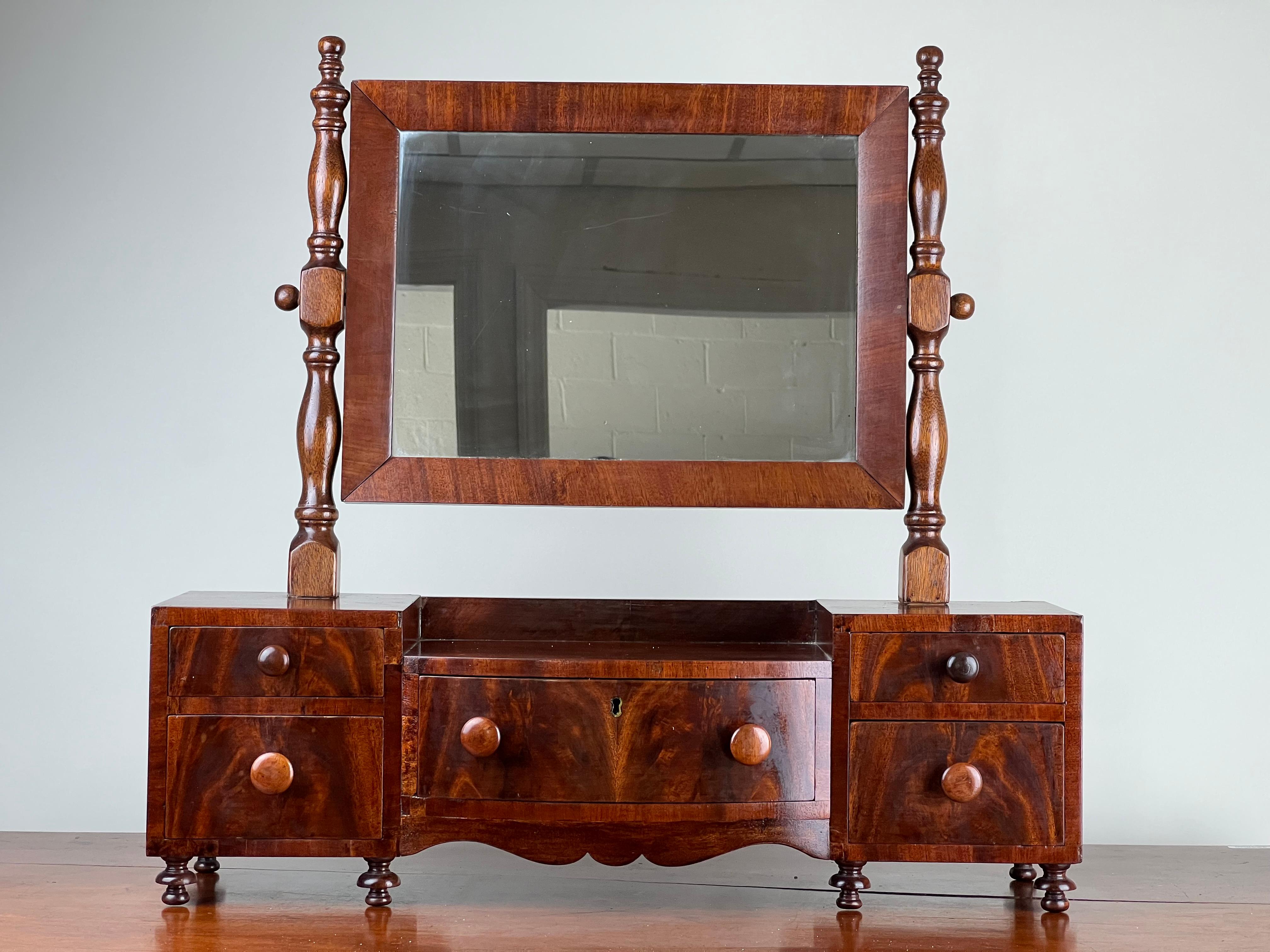 Questo splendido specchio da barba a goccia centrale di epoca Feder, risalente ai primi anni del XIX secolo, riflette la raffinatezza e la praticità del design americano. Realizzato in ricco mogano, lo specchio è incorniciato da robusti supporti