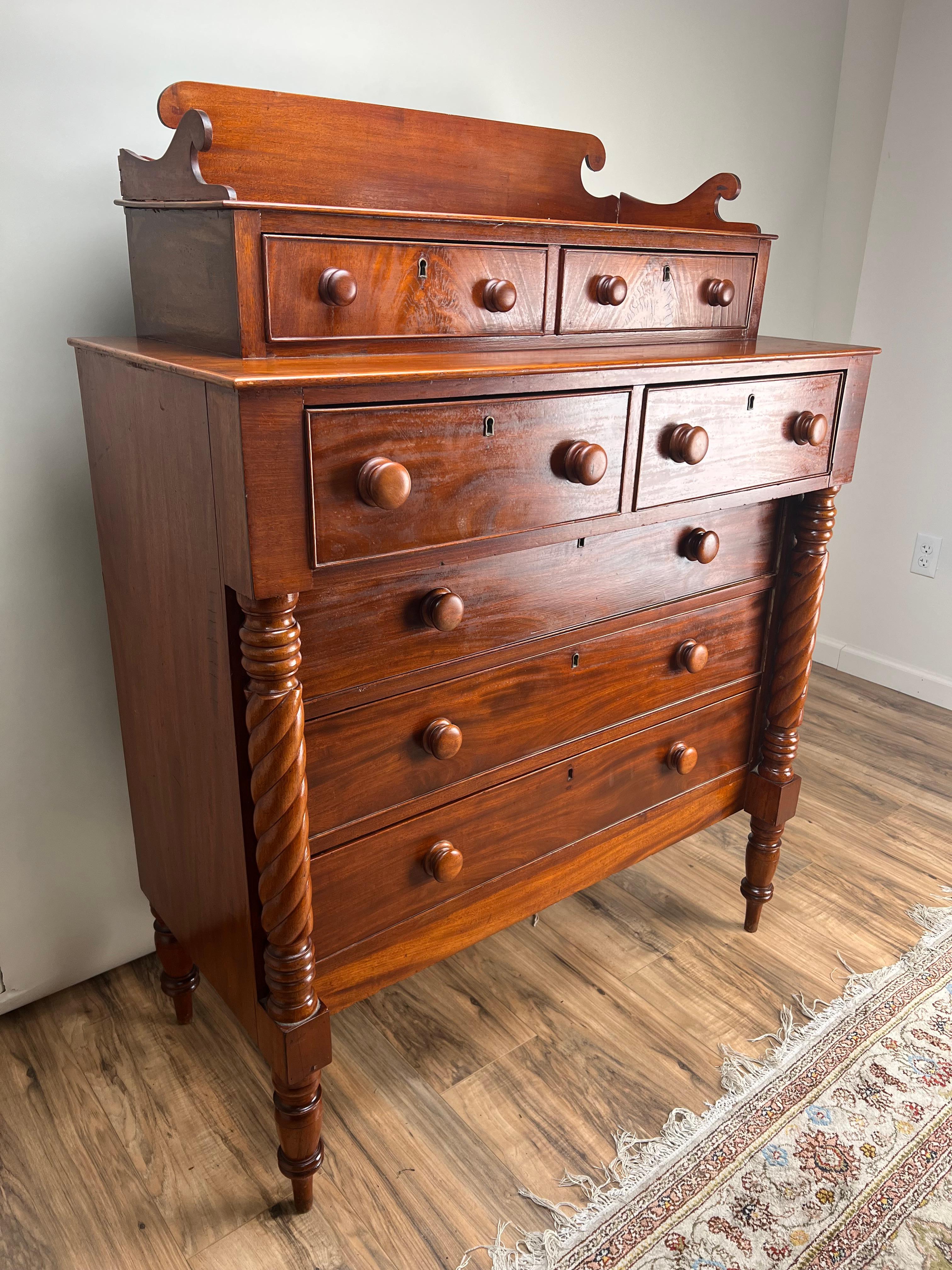 A stunning Federal period Sheraton deck-top chest of drawers, crafted in rich mahogany and dating to circa 1820, this piece showcases the elegance and symmetry characteristic of early 19th-century American furniture. The deck top features two small