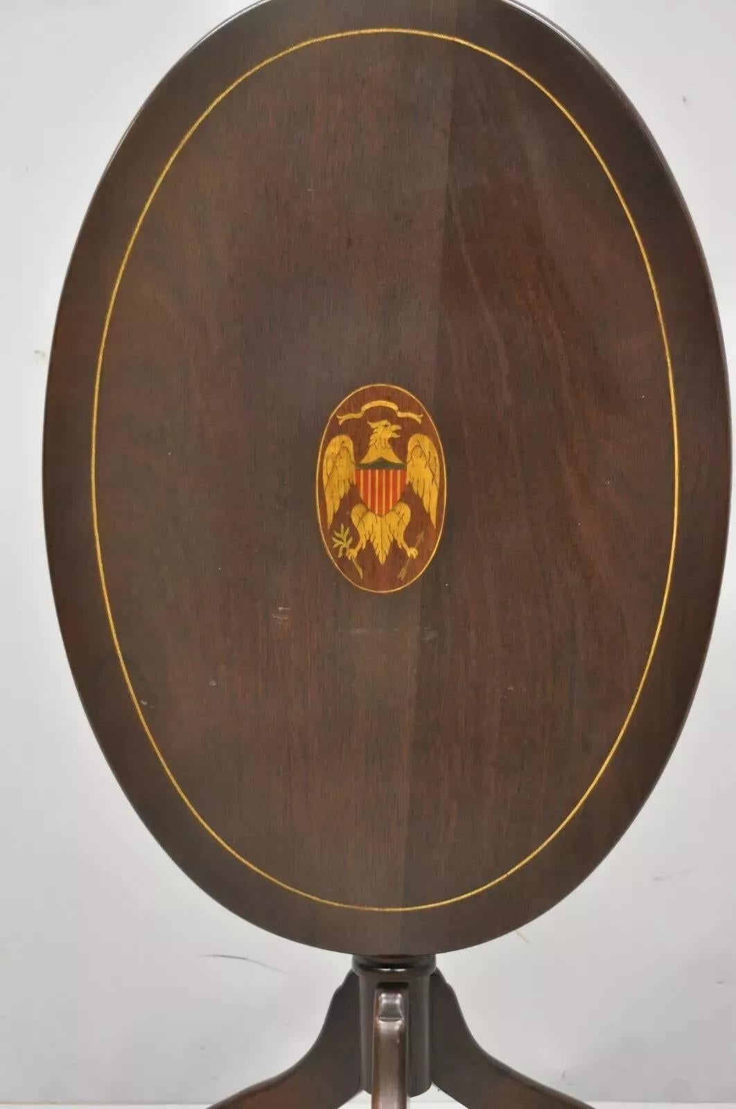 Ancienne table de lampe fédérale Sheraton en acajou avec incrustation du bouclier de l'aigle et du drapeau, à plateau inclinable. L'objet présente un aigle central incrusté avec un bouclier et un drapeau, un plateau basculant, des incrustations, une
