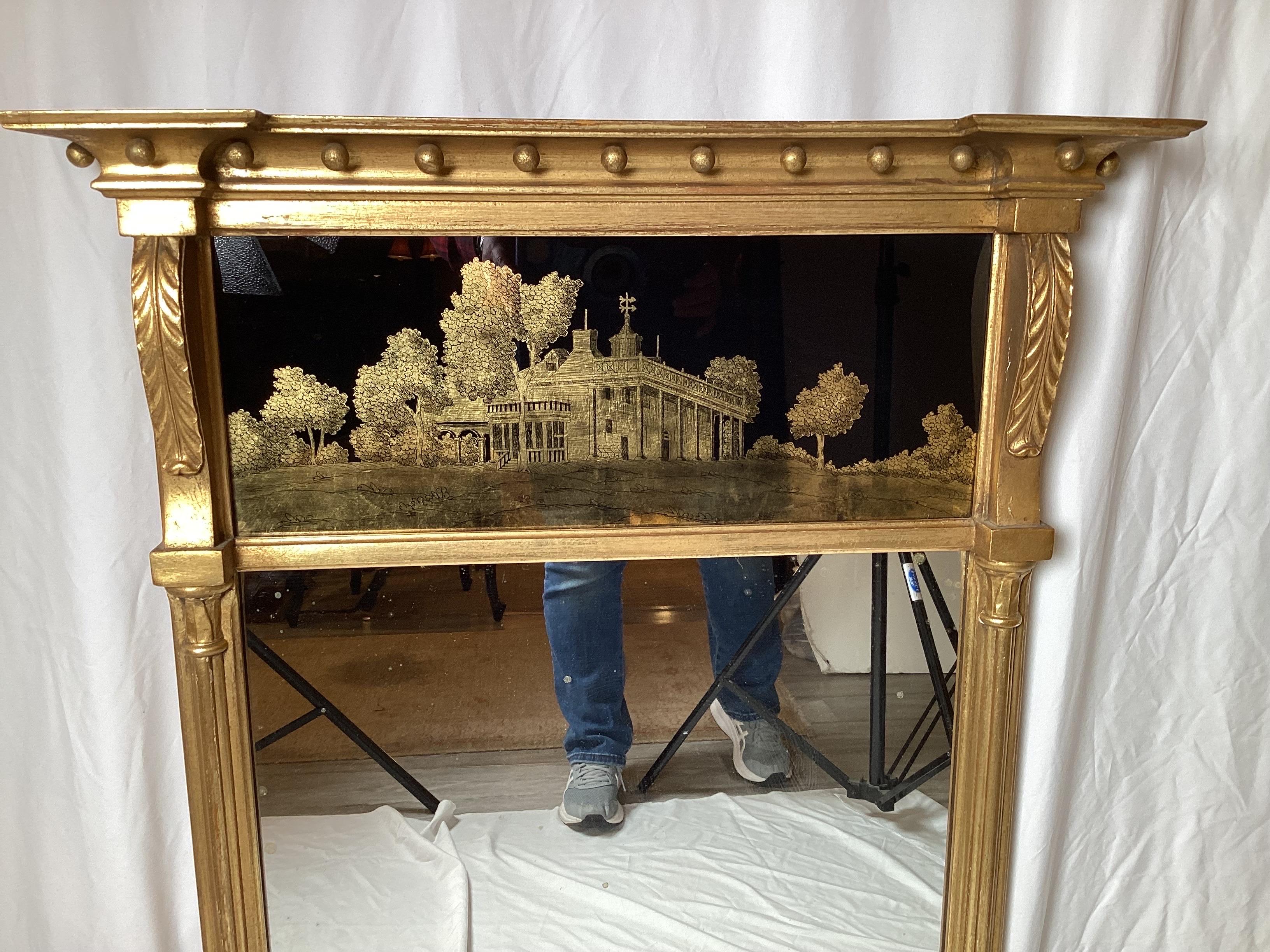 Handsome Late 19th Century Federal style wall mirror. The original gilt on the frame with an eglomise picture of Monticello in trumeau mirror style. The mirror silvering is original with some minor age spotting. The gilt in very good original