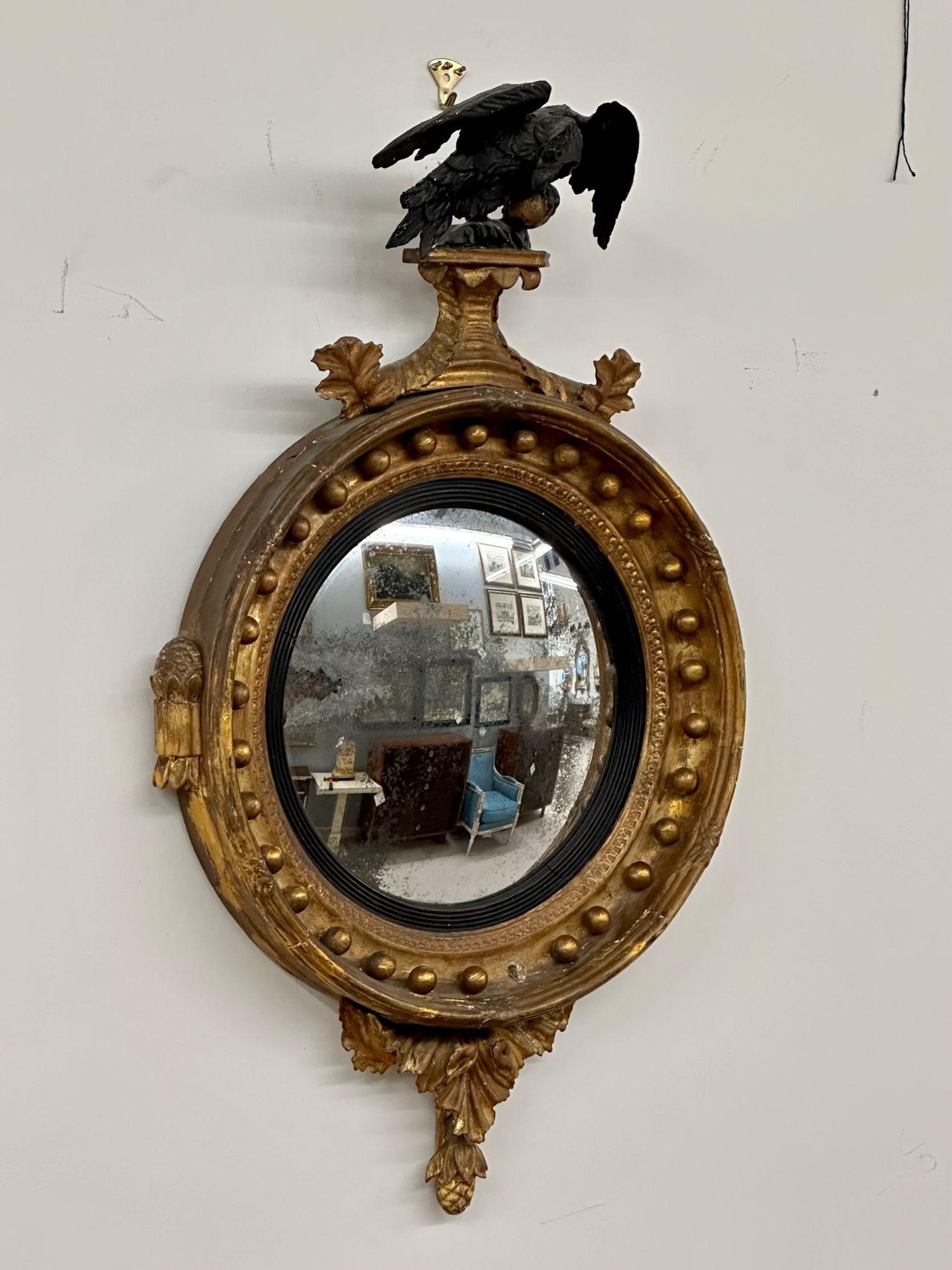 Antique Federal style gilt gold convex wall / console / pier mirror, distressed
 
Antique, Federal Style, 19th C. round wall mirror bearing a subtle convex center glass. Detailing is beautifully crafted in giltwood and ebonized wood. A