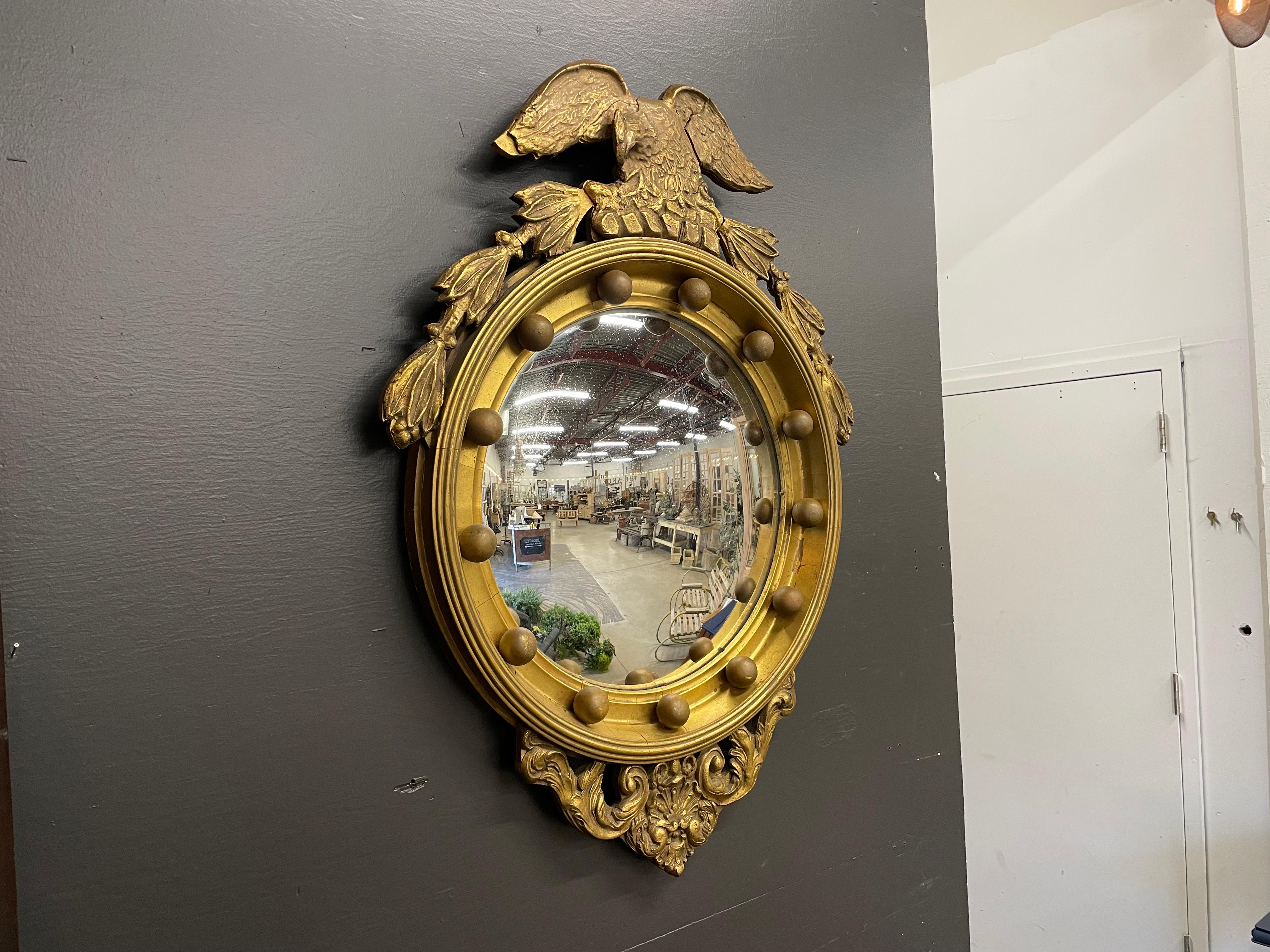 Antique Federal style gilt wood convex eagle mirror. 

During Thomas Jefferson’s presidency, there was a strong sense of nationalism. Jefferson was inspired by the classical past when creating the new American democratic Republic.

The convex eagle