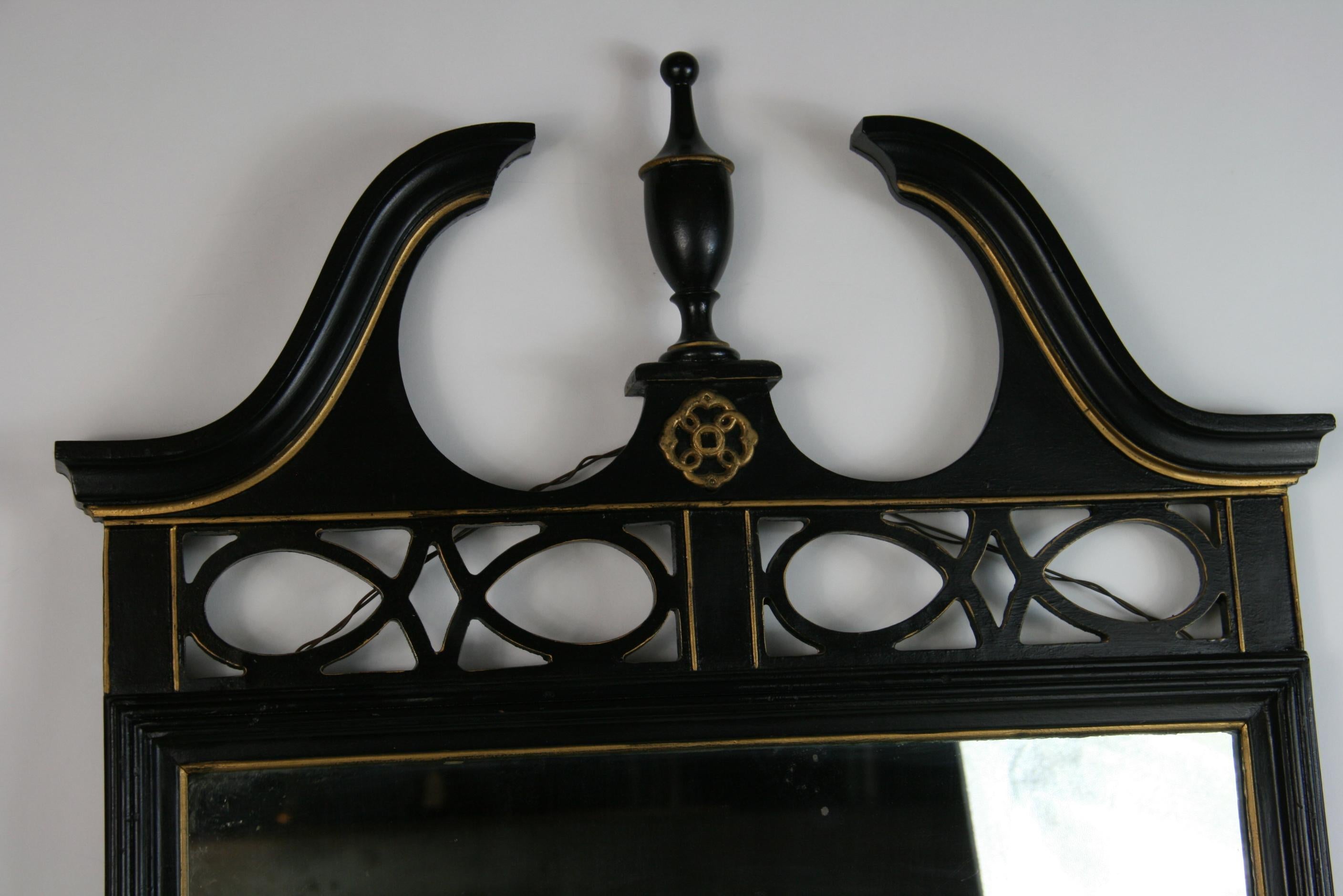 Miroir en bois noir de style Feder avec détails dorés.